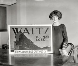 February 25, 1924. Washington, D.C. "Miss Ann O'Connell." Evidently not one to run (or drive) with the fast crowd. National Photo Co. View full size.
Original artwork.This may be a watercolor painted on an illustration board or watercolor board. Note the hand lettered headline. The subhead (Cross Crossings Cautiously) looks to be typeset and could have been pasted onto the artwork. The next step would be to take it to the engraver for printing plates (if this was meant for reproduction)!
Off the CuffOne of those Shorpy moments I regret the monochrome - I would love to see the colours in Miss O'Connell's dress. The Futurist sleeves could have come straight out of the film "Metropolis" and must have been the cutting edge of fashion in 1924.  
T-H-A-T"Railroad crossing, look out for the cars. Can you spell that without any R's?" Wish I had a nickel for every time I heard it in the '50s.
Cautious in ColorI give you my crude and amateurish attempt at colorization. It shouldn't take long to see that I am inept at Photoshop so I cheated with a quick cut &amp; paste.
[Certainly an improvement on her boring gray poster! - Dave]
Campaign to Cut Crossing WrecksWhere it all began (NYT link):
The ArtistMiss O'Connell was a stenographer at the American Railway Association, but she was not responsible for the artwork she is propping up. The artist behind this design was actually Martin H. Gambee (1905 - 1969) who was attending the Pratt Institute in Brooklyn, New York at the time. 
The contest attracted 5,000 poster entries and 20,000 slogan entries. The announcement of his win was in February 1924, but the award presentation was not made until May 10, 1924 in Washington, D.C. The poster was used in a safety campaign from June through September 1924. Gambee's photo and more details of the contest are below.
(The Gallery, D.C., Natl Photo, Railroads)
