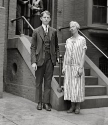 June 3, 1924. "Leonard and Edna Wilbur," children of Navy Secretary Curtis Wilbur. National Photo Company Collection glass negative. View full size.
Edna &amp; OnaFrom the Lima (Ohio) News, April 9, 1928:
Rescued by forest rangers from a narrow ledge 2,000 feet high, where darkness had trapped her and her girl companion during a trip thru Yosemite valley, Miss Edna May Wilbur, daughter of Secretary of the Navy Curtis D. Wilbur, was home here none the worse for her thrilling experience. Miss Wilbur went to the park with a party of friends. She and Miss Ona E. Ring attempted late Saturday to descend the snow-covered trail from Glacier point to the floor of the valley. Caught by darkness, they lost the trail and presently found themselves on the narrow ledge, whence they feared to attempt further progress. With a biting mountain wind tugging at their clothing, the girls huddled against the face of the cliff and called for help. Tourists in the valley, 2,000 feet below, heard their cries, and notified the forest rangers. Five men reached the girls shortly before midnight, and strenuous efforts succeeded in hauling them up to the trail with ropes.
[Thrilling! I think this was an episode of "Leave It to Beaver." - Dave]
Tats or Vacs?Those circular things on her arms. Can I assume that they were vaccination scars? She certainly has a modern attitude or so it seems.
[That's mold on the emulsion. - Dave]
Yes, DaveYes, the episode wherein the Beav climbs into a teacup and can't climb out and is rescued by the fire department. Amazing how daring Miss Wilbur was - that explains the dress.
[Not quite. I was thinking of the episode where Beaver and Gilbert go camping, get stuck on a ledge and are rescued by park rangers. - Dave]
Still waters run deepMiss Edna has a certain sly gleam in her eye. I'll bet she danced a few Charlestons in her time while Dad was off minding the boats.
Edna Does D.C.Atlanta Constitution, 11 July 1924
New Cabinet Daughter
Lands in Capital
And Looks it Over

Washington's newest cabinet daughter has been spending her first few days in the capital just like anybody's daughter here on an excursion trip -sightseeing.
Miss Edna Wilbur, whose father is secretary of the navy, arrived last Thursday from California.  She came through the Panama canal with her brother, Leonard Wilbur, and then up the Chesapeake bay and the Potomac, from Hampton Roads, on the neat little yacht Sylph, which is at her father's disposal as boss of the navy.
...
Miss Wilbur is Washington's third cabinet daughter of marriageable or debutante age.  Both the other two aren't braving hot weather here.
...
Miss Wilbur has another cabinet distinction besides braving Washington heat.  She's the only daughter of a cabinet member who knows how it feels to spend money earned by herself.
The daughter of the navy secretary is a California high school teacher and she didn't give up her job just because her father is a member of President Coolidge's cabinet ...
Miss Wilbur is a tall girl, with much pale yellow hair and a fair skin.  Not pretty, but attractive looking.  And not the debutante or flapper type.
She is quiet and self-possessed.  She has the voice and manner of a successful teacher.
And --no, her hair is not bobbed!

A Boston Globe article from April 13, 1924 says Edna graduated from Stanford with a degree in French.  She was teaching at Chico High School.
Leonard or Lyman, perhaps Paul?I've been doing some research on Curtis Wilbur and all the sites list his children as Edna, Paul and Lyman. Perhaps Leonard was a nickname or is this a typo?
[Leonard Wilbur's name makes dozens of appearances in the historical archives of various newspapers. See the next comment up. - Dave]
Dr. Leonard Wilbur&#039;s mission Young Leonard would lead an inspiring, but all too short, life.  After graduating from medical school at Stanford (where his uncle had been a president) he and his wife embarked upon a mission to Northern China, starting a hospital in the province now known as Shanxi.  First the communist insurgents invaded (and the Wilburs were reported missing) in 1936. They resurfaced, but in late 1937 the Japanese invaded Shanxi (and the Wilburs were again reported missing but resurfaced). On Easter in 1940, during the Japanese occupation, Leonard died of typhus. He was only 33. His wife survived, and became one of the heirs to father-in-law Curtis Wilbur's inheritence when he died in 1954.    
Sorry, Miss Edna.I guess you weren't the flapper I took you to be. The sly gleam must have been that look you gave your students to let them know you meant business.
Wilbur childrenCurtis D Wilbur had 5 children...
1.  Ralph 3/18/1903 - 3/24/1906 age ~3
2.  Leonard 3/2/1907 - 3/24/1940 age 33.
3.  Edna was 25 in this photo, and Leonard 17.
From Pathways: A Story of Trails and Men (1968) by John W. Bingaman--
The Ledge Trail:  "In 1871, James M. Hutchings had been guiding parties of hikers to Glacier Point over a most hazardous trail, which he had blazed up the Ledge and through the chimney and which climbed 3,200 feet in approximately one and a half miles to Glacier Point. This was the Ledge Trail.
In 1918, it was repaired by the Park Service. It was a dangerous climb because it was partly built of solid rock, and extremely steep, much like a staircase. Rock slides occurred frequently causing accidents to climbers. Only up-travel was permitted by the park regulations in later years. After several major floods, rock slides, injuries, and deaths to climbers the park authorities deemed it necessary to close this trail to all hikers. The Author assisted in rescue parties several times on this trail."
Edna hiked the Sierra's of California until she was 90.
4 &amp; 5.  Paul and Lyman lived until they were 100. 
(The Gallery, D.C., Natl Photo)