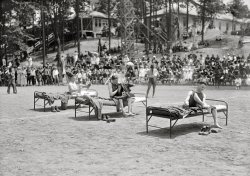 1919. "Fourth of July. Scenes in celebration at Walter Reed Hospital." The ever-popular Competitive Napping event, maybe. Or would this demonstration have another purpose? Harris &amp; Ewing Collection. View full size.
Missing BitsWell they are all missing at least part of an arm. So I'd guess it's a race to see who can get dressed the most quickly as a demonstration how well they've done in their rehab.
One two three.I see a missing arm and two missing hands (three if you want to get technical). Good luck, boys, and thanks.
Competitive DressingThe Washington Post fails to mention any one-handed dressing races but notes that other competitions  of the day included "an artificial leg walk, a thirty-yard hop and a crutch race."
PutteesI'd love to see them try to wrap those puttees you see rolled up next to their shoes.  
Here's a How-to.  
Puttees IIWell, the guy whose arm is completely gone doesn't have any puttees by his shoes. Perhaps with most of an arm to hold things in place, the puttee is considered doable.
And what about the middle guy's right leg? Did he get his calf muscle shot off, or did he have polio?
[Neither. The blanket is hiding it. - Dave]
ContestThey are racing to see who can be first to go from bedded down to dressed and ready to go. My money is on the guy in the middle!
Puttees in your handAs a history teacher, I wear a WWI uniform three or four times a year. Puttees are fun enough when you have two hands -- this is ridiculous!
(The Gallery, D.C., Harris + Ewing, WWI)
