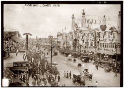 July 16, 1913. Surf Avenue on Coney Island, with Feltman's Clam Bake on the left. View full size. 5x7 glass negative, George Grantham Bain Collection.
Feltman&#039;sLocated on the south side of Surf Avenue, Feltman was best known for his high grade and more expensive hot dogs. His place though was much more than a hot dog stand. It featured the hot dog counter facing Surf Avenue on the east side nearest the camera where root beer, Moxie and other soft drinks were sold along the hot dogs, hamburgers and fries. The counter was a rectangle with serving surfaces on all four faces, three of which were inside the main building. To the west of the building was the clam bar on the other side of the main entrance which led to the bar area located beyond the clam bar and sit down tables. Behind the hot dog counter were sit down tables where you could order meals and beverages from waiters.Behind the bar was the kitchen area that prepared food for the restaurant and also the outdoor Beer Garden which ran from the rear of the building along toward the ocean. The rest rooms were located beyond the sit down tables on the same side as the hot dog counter. The Garden  feature a Bohemian theme with the east wall featuring faux buildings in the theme fashion with windows, doors and red tile roofs and the walls stucco finished a  grayish tan color. Special colored lamps provided lighting and live entertainment and dancing were featured at night.Select vegetation enhanced the atmosphere. There were singing waiters and strolling minstrels. Jimmy Durante and Eddie Cantor worked there when they were young.
Whew!!I look at the date of this picture then look at the clothing everyone is wearing and I start to sweat!  I can't imagine having to dress like that in mid-summer in NY.
JFLundyIs Mr. Lundy a part of the famous Lundy family who owned the best restaurant in Brooklyn?  I ate at Lundy Brothers many times as a boy in the 40's and 50's, and recall the biscuits and shore dinner with gustatory delight.
A centuryI find it totally mind blowing to think of how our world has changed in less than a century, when you take into the consideration how long we have been on this planet and in the context of 100 years, how our world and society has changed.   I sometimes wonder is it for the better?  This picture was taken two weeks before my father's birth. Sure puts things into a different light.
(The Gallery, Coney Island, G.G. Bain, Sports)