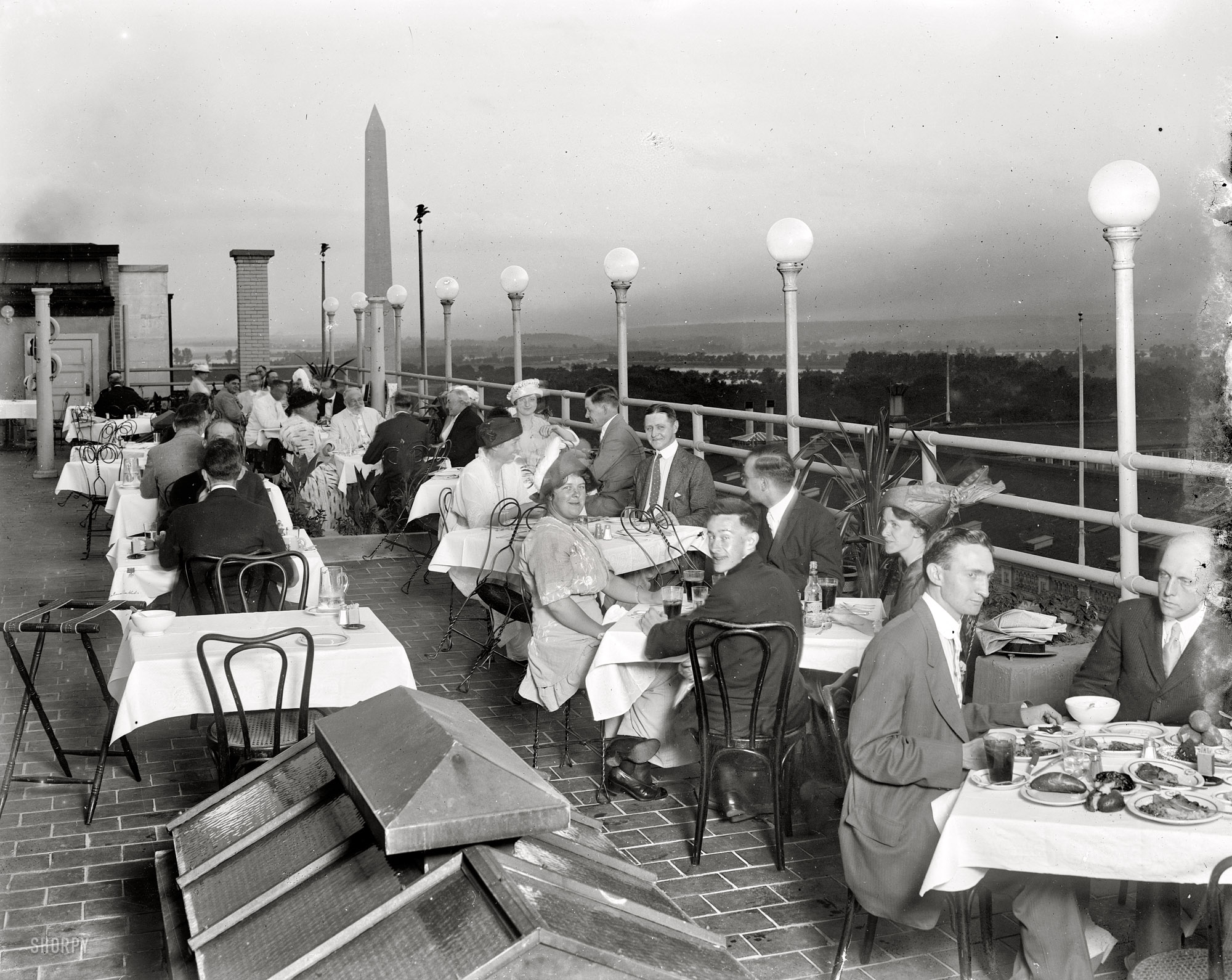 "No caption." Rooftop dining somewhere near the Washington Monument circa 1920. Harris & Ewing Collection glass negative. View full size.