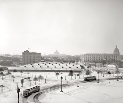 January 1918. Washington, D.C. "Billy Sunday tabernacle." A temporary meeting hall built near Union Station for a three-month series of revival meetings held by the famous evangelist. Harris &amp; Ewing Collection glass negative. View full size.
Streetcars!According to an article in The Post this week, streetcars are about to return to DC after a 50-year absence.
There it is!The honest to god, original Tourist Motel!
And to think, it all started because of Billy Sunday... 
Well, probably not, but I love the hotel name.
Photographer&#039;s Vantage PointThe photographer's vantage point seems to be from an upper level window or the roof at the SE corner of the Union Station building. The view is looking south with First Street NE extending in the distance towards the Library of Congress dome. 
What a weird structureAnd it looks like someone's been snowboarding off the roof.
Not seen in this photois a temporary wall of separation between church and state.
Switch TowerCan anybody identify the function of the elevated tower at the front left of the photo? I'm guessing that it might house the controls for the switches on the trolley car tracks. That might also explain the semaphore like device sticking out of the roof.
[That "semaphore" is a street sign on the lamppost near the horse. The switch tower is described in the comments under this photo. - Dave]
Popular EvangelistBilly Sunday, born in poverty and raised in an orphanage, was a magnetic personality who, after playing professional baseball in the 1880s, became one of the most popular Bible-thumping evangelists of his time. He was a large cog in the wheel that foisted Prohibition on America. Unlike many of his peers, before and since, Billy seems not to have had feet of clay.
Outfielder Billy SundayHow many knew that, in his 20s, the legendary Rev. Billy Sunday (1862-1935) spent 8 years as a big league outfielder with Chicago, Pittsburgh and Philadelphia in the National League? Could it have been his .248 career batting average that inspired him to give up his baseball career for a higher calling? 
Out-of-townerAnybody know what that big dome-y structure up on the hill is? (You can have them ring me at my rooms in The Tourist.)
IncendiaryI'll bet the D.C. fire marshal held his breath for 3 months.
The Ghostly Horse And WagonThe horse and wagon to the extreme right look like true ghosts to me. They're very faint and I can see what looks like the entire curb behind them. They do cast shadows so I'm not calling on the supernatural to explain it yet. I've never seen such large moving objects look so ghostly with such sharp outlines. As an aside, there is an almost invisible bicyclist who is also casting a shadow midway between the trolleys.
Clean snow!By the number of wheel tracks in the snow, you can tell it's been on the ground awhile.  With that in mind,  it's nice to see WHITE snow.  Those were the days of clean air.
[The air of 1918 was considerably dirtier than it is now. Coal soot. - Dave]
Who was the evangelist ?Billy Graham is the only one named Billy that I ever knew but he was born in 1918 so not likely to have preached the same year. Which "Billy" was speaking here ??
[Billy Sunday. Like it says in the title and the caption. - Dave]
Thanks Dave, I thought it meant that it was on a Sunday and since it is a tabernacle it is normal to think that. But thanks for answering.
[Aha! You're welcome. - Dave]
Urban and Spiritual RenewalDuring the early-century maneuvering over how to memorialize Lincoln, one of the sites considered was this general area, which was a slum between Capitol Hill and Union Station.  The Lincoln Memorial was going to go up elsewhere, but it appears that a way was found to clear out the slums and simultaneously promote righteousness.
Eloquent, at times

Washington Post, May 25, 1889 


Billy Sunday as a Revivalist

Billy Sunday, the clever right-fielder of the Pittsburg club, doffed his baseball uniform and made his first appearance in this city in the role of a revivalist, at the Central Union Mission last night.  The hall was pretty well filled, and a great many came in while he was speaking. None of the members of either the Pittsburg or Washington clubs were present.  After a service of song and a prayer by Mr. Sunday, he selected a text from the first chapter of John, fourth and fifth verses.  The short sermon which followed was replete with interest, forcibly and, at times, eloquently given.  He closed with a short prayer.


Washington Post, Nov 6, 1917 


Ground is Broken for Tabernacle

Ground was broken in front of the Union Station plaza yesterday for the tabernacle which is to house the Billy Sunday revival here in January.  The actual turning of the sod was performed by John C. Letts, chairman of the Sunday campaign committee.  Post-master M.O. Chance presided.
The ceremony took place under one of the big Union Station flags at 12:15 o'clock p.m. in the presence of several hundred people who stood with bared heads until the exercises were completed.
The Rev. Charles Wood, pastor of the Church of the Covenant, and the Rev. James Gordon, of the First Congregational Church, delivered the prayers.  Dr. James E. Walker, representing Billy Sunday, in his address said that Sunday comes to Washington to preach the simple word of God.  "Not Mr. Sunday, but Washington is on trial," he concluded.
The permit to erect the tabernacle bears the signatures of Champ Clark, Vice President Marshall, and Supt. E.H. Woods, of the Capitol.

Another Billy Sunday referenceChicago, Chicago that toddling town
Chicago, Chicago I will show you around - I love it
Bet your bottom dollar you lose the blues in Chicago, Chicago
The town that Billy Sunday could not shut down
BrrrThe winter of 1917-18 was one of the coldest and snowiest of the 20th century. Many cold records were set that remain unbroken 90 years later. 
http://www.semp.us/publications/biot_reader.php?BiotID=637
Room at the TouristWell, you can stay there, but I'm booking a room at the Hotel Wilmat, they have 'ROOMS'
(The Gallery, D.C., Harris + Ewing, Railroads, Streetcars)
