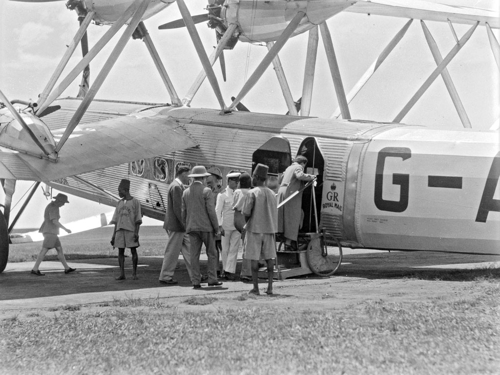 Travelers board an aircraft in an unknown region of Africa. From the Matson Photo Service, 1936. View full size.