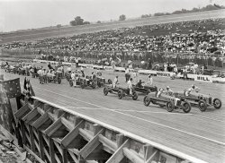 July 11, 1925. Our third look at the lineup on Laurel Speedway's board track. National Photo Company Collection glass negative. View full size.
Jaw DroppingI just cannot get over a track made entirely from wooden planks. The fact the corners are so steeply banked too...
Wow, just, wow...
Good Seats Still Available
Dash for a New Record
Championship Auto Race

(click to enlarge)

Splinters!In his book "500 Miles to Go" racing legend Wilbur Shaw talked about racing on board tracks like this. He said that splinters of varying sizes flew into his arms around where his elbows stuck out and that kids would sneak under the track and poke their heads up through the track where the boards weren't "in the groove." He didn't like racing on board tracks but a paycheck was a paycheck.  Can't imagine many drivers wanting to race in those conditions today.
(The Gallery, Cars, Trucks, Buses, Natl Photo, Sports)