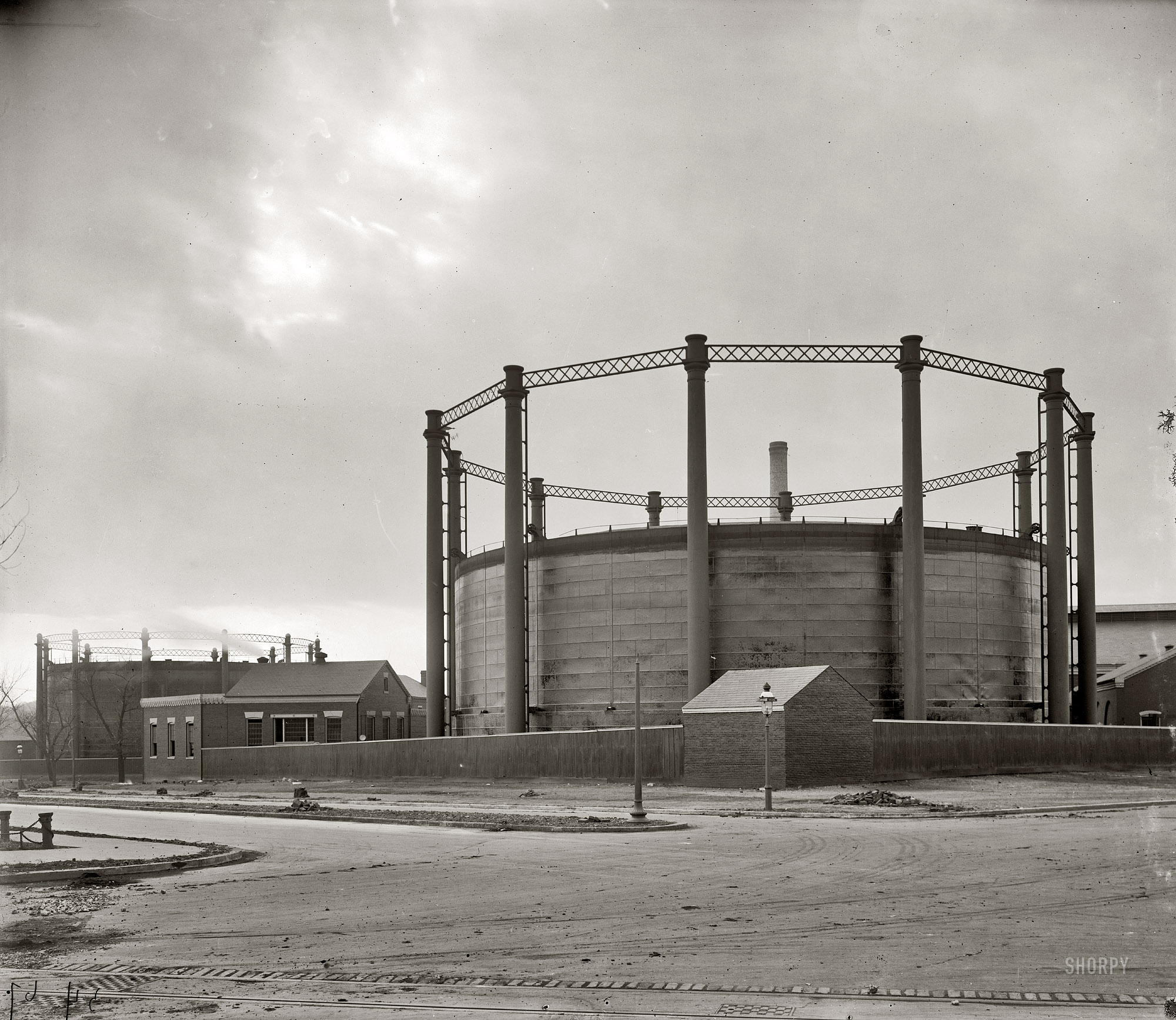 "Gas tank at 26th & G." The city gas house and holding tanks ("gasometers") in Northwest Washington near the current location of the Watergate complex. The intersection in the photo (seen earlier here) is New Hampshire (middle left) and Virginia avenues. Harris & Ewing Collection glass negative. View full size.