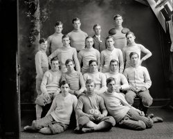 Washington, D.C., circa 1905. "Eastern High School football team." Harris &amp; Ewing Collection glass negative, Library of Congress. View full size.
Must be a misprintIt's the drama club or chess team. If it were the football team, we'd see tribal tattoos, piercings, thuggish scowls, baggy t-shirts and shorts.
The Light Blue &amp; WhiteThis photo ran in the Washington Post on June 10, 1906 as part of a two page spread of class and team photos.  Graduation exercises that year were scheduled on June 20th.



Eastern High's Captain
Leader for Football Team Will Not Be
Elected at Present 

Eastern will be the last of the high schools to elect a captain.  As there is some uncertainty as to the returning of one of the players, it has been decided to wait some time before choosing a leader for next season.  The Capitol Hill eleven will lose heavily from graduation, but it is thought that from the regulars left over from this fall will be a strong nucleus to build a team to better the record made by the light Blue and White during the season just closed.
Capt. Field, whose work marked him as one of the starts of the High School League, will be missing, and to find some one to fill his old position will be one of the hardest tasks next year.  The veterans who will be eligible to play next fall are Farmer, Titus, Pyles, Palmer, Tewksberry, Brown, Dodd, the Richardson brothers, Martin and Jones.  During the season just closed Eastern was greatly handicapped by constant changes, no less than five coaches having charge of the players at different times, but next season with a more settled policy, it is expected that a stronger aggregation will be developed.

Washington Post, Dec 4, 1905


Northern ExposureA gorgeous portrait that reveals the natural light techniques of the studio photographer at the time.  A pulley system operating individual blackout curtains for each pane of the window in order to adjust the light.
Football TrophiesIf he is proudly displaying two trophy livers knocked out of opponents, like scalps on a warrior's belt, that tall guy was one heck of a hard hitting football player.  Too bad I can't sign him for my Detroit Lions.
BallerinasThe two guys in front look more like ballerinas than football players. It seems that they are not wearing numbers on their uniforms yet. Years later when they begin to, they'll be numbered consecutively 1 through 17, as we learned in a previous Shorpy history lesson on glass.
Stitch &amp; TimeWow. Now I know what to submit to my mother-in-law for my Christmas knitting wish list. Tthose are some excellent looking sweaters.
Questions: I have noticed that sometimes on these portraits there might be one or two blurred faces, does anyone know what the exposure time for a photo like this might have been?
Natural light with flash powder?  Would glass negatives have had a ASA rating at that time?
[The ASA (American Standards Association) didn't exist in 1905. - Dave]
The LookI used to think that people of earlier generations had radically different faces from today's people. but now I'm not so sure. Give those young men a change of clothes and a few tats and piercings, and they would blend right in.
Shorpe DiemAnyone else thinking of the movie "Dead Poets Society"?
They're not that different from you, are they? Same haircuts. Full of hormones, just like you. Invincible, just like you feel. The world is their oyster. They believe they're destined for great things, just like many of you, their eyes are full of hope, just like you. Did they wait until it was too late to make from their lives even one iota of what they were capable? Because, you see gentlemen, these boys are now fertilizing daffodils. But if you listen real close, you can hear them whisper their legacy to you. Go on, lean in. Listen, you hear it? - -- Carpe -- hear it? -- Carpe, carpe diem, seize the day boys, make your lives extraordinary.
GleamThat guy in the second row, second from the left, sure has a gleam in his eye! I'll bet he liked the girls, and vice-versa!
(The Gallery, D.C., Harris + Ewing, Sports)