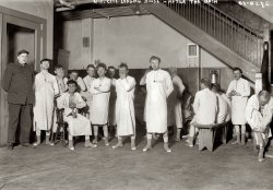 New York City municipal lodging house circa 1909. "After the bath." This is the answer to those wondering what you'd wear while your clothes were being fumigated overnight. George Grantham Bain Collection. View full size.
DPCThe guy in uniform looks like he belongs with the Department of Public Corrections instead of Department of Public Charities.
Those tags around their necks must match numbered tags on their clothing undergoing fumigation.
SocksThe man second from the right didn't get his new government-issued socks, apparently.
ScarySort of looks like a picture taken in an early 1900's mental institution.
(The Gallery, G.G. Bain, NYC)