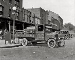 Washington, D.C., circa 1926. "Ford Motor Co., Hatcher Boaze truck." A nice view of the old market district. National Photo Co. glass negative. View full size.
No such intersection nowThere doesn't appear to be an intersection of 10th and Louisiana, N.W. in Washington any more.  Was Louisiana Avenue renamed?  Where was this?
[This stretch of Louisiana Avenue was obliterated during construction of the Federal Triangle complex of government buildings in the 1930s. This block would be under the current Department of Justice. More here. - Dave]

John Waters &quot;Pink Flamingos&quot;At the risk of sounding like a pervert, this immediately brought to mind John Water's depraved film named above from 1972, since the friendly "Mr. Eggman" was the character who delivered eggs daily to Divine's mother, Eddie, who idolized eggs and needed a constant supply.  It took place in a trailer park just outside Baltimore which isn't that far removed from Washington, D.C., but the movie is definitely not for everyone.  Its just that Eddie always worried constantly that one day there would be "no more eggs".  It is NOT a family film.  When I was a kid, we had an egg lady, a farmer's wife, who brought us the most wonderful brown eggs weekly.  Thank you Mrs. Lennon, wherever you are.  Them were the best ever.
Wm. H. Boaze

Washington Post, Nov 19, 1952 


William H. Boaze
Funeral Rites Today

William H. Boaze, 72, a resident of the District since 1907, died Sunday at Sibley Hospital after a three-months' illness.  He lived at 1335 Jefferson st. nw.
A native of Danville, Va., he operated the W.H. Boaze Company, now the B.P. Boaze Real Estate, 3408 18th st ne., for more than 10 years.  ...  For 20 years he owned and operated the Loudoun Produce Company on 10th st. nw.
He is survived by his wife, Mrs. Nettie Keifer Boaze of the Jefferson st. address; three sisters and two brothers.

A little yolkHmmm ... Hatcher ... eggs ... I get it.
Speaking of eggs and Maryland and all that, wasn't that great movie with Fred MacMurray and Claudette Colbert, "The Egg and I," set in Maryland?  It was produced in 1948, but the actual story took place during the '20s and '30s.  Very dear movie.
Draw-overOk, not exactly a colorized photo; rather a cartoonized version of that truck. Hope you like it.
Of course, no original photo was damaged in the making of this drawing.
P.F."...and they were the BEST EGGS IN TAYWN!!!" 
Reminded me of something elseI thought of the Louis Armstrong song, "Butter and Egg Man"
Now she wants...a butter an egg man
A great big butter and egg man
From way down south
I am the egg-man......they are the egg-men.  I am the walrus.  Goo-goo-ga-joob.
Goo goo g&#039; joobIf only the driver had a big ol' walrus mustache, it would be perfect.
Happy Birthday JohnOct. 9 is also John Lennon's birthday and as you know he is the eggman.
WORLD EGG DAY TODAYI don't mean to hog the comment board, but I just heard on the noon news that today, Oct. 9th, is "world egg day" and I immediately thought of your eggman picture.  Being that you stay so current and savvy, I bet you knew this when you posted it a bit early, huh?
Great Detail!Such a great shot, two things I noticed. The owner of the truck has installed a choke wire for the carb to aid in starting the beast in the morning. Pull the choke closed and give her a spin of the crank which would send a rich charge of fuel into the intake. Run around to the cab and turn the  ignition on, then back to give her another spin. If the gods were in your favor she'd fire right up!
The other thing was the size of the crate-sitter's feet. Half of him is on the ground!
(The Gallery, Cars, Trucks, Buses, D.C., Natl Photo, Stores & Markets)