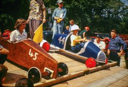 Car 45 vs. Car 44 in the 1952 Soap Box Derby 1952 in Elmwood, Illinois. Car 45 won, ending the tournament in a 4 way tie with Cars 13-16-81.
__________________
Massey Wins "Rocket Derby" as 78 Entrants Vie for Prizes
Robert Massey of Muscatine, Iowa, driving car number 71, won first Place in the A division of the 1952 "Rocket Derby," held Saturday, September 6 in Elmwood.
Massey's time for the course averaged 25.8 seconds. Second place went to Ronald Brisker of Bushnell in car number 19 while the 3rd place trophy was won by Dean Vance, son of Mr, and Mrs. Cornelius Vance of Elmwood, driving car 98. Dean was one of the most consistent drivers of the day, going down the hill four times in 26.3 seconds and twice in 26.5. There were 52 cars which ran in the A division and 26 cars in the B division. Three cars entered earlier in the A division did not run.
Cars in the A group finished in this order: 71, 19, 98. 52, 3 and 15 tie. 83, 1-17-29-55-60-88 tie, 22, 61, 13-16-45-81, tie, 11-14-41-43-91 tie, 56, 74-87 tie, 10-30 tie, 39, 12, 5, 21-25 tie. 44-78 tie, 92, 20-82-100 tie. 53, 35, 48, 64, 24, 46-57 tie, 7, 8. 33, 62, 49. Average times ranged from 25.8 seconds to 30 seconds. 
Competing against 25 other entrants in the B division, Ronnie Ecklund. son of Mr. and Mrs. A. W. Ecklund of Elmwood, drove car 47 to first place in this group, with George Shaheen, son of Mr. and Mrs. Louis Shaheen of Elmwood, winning second place. Ronnie's average time was 35.55 while Shaheen's time was 36.35. Shaheen made one run of 34.2 for the fastest time of the day.
(ShorpyBlog, Member Gallery)