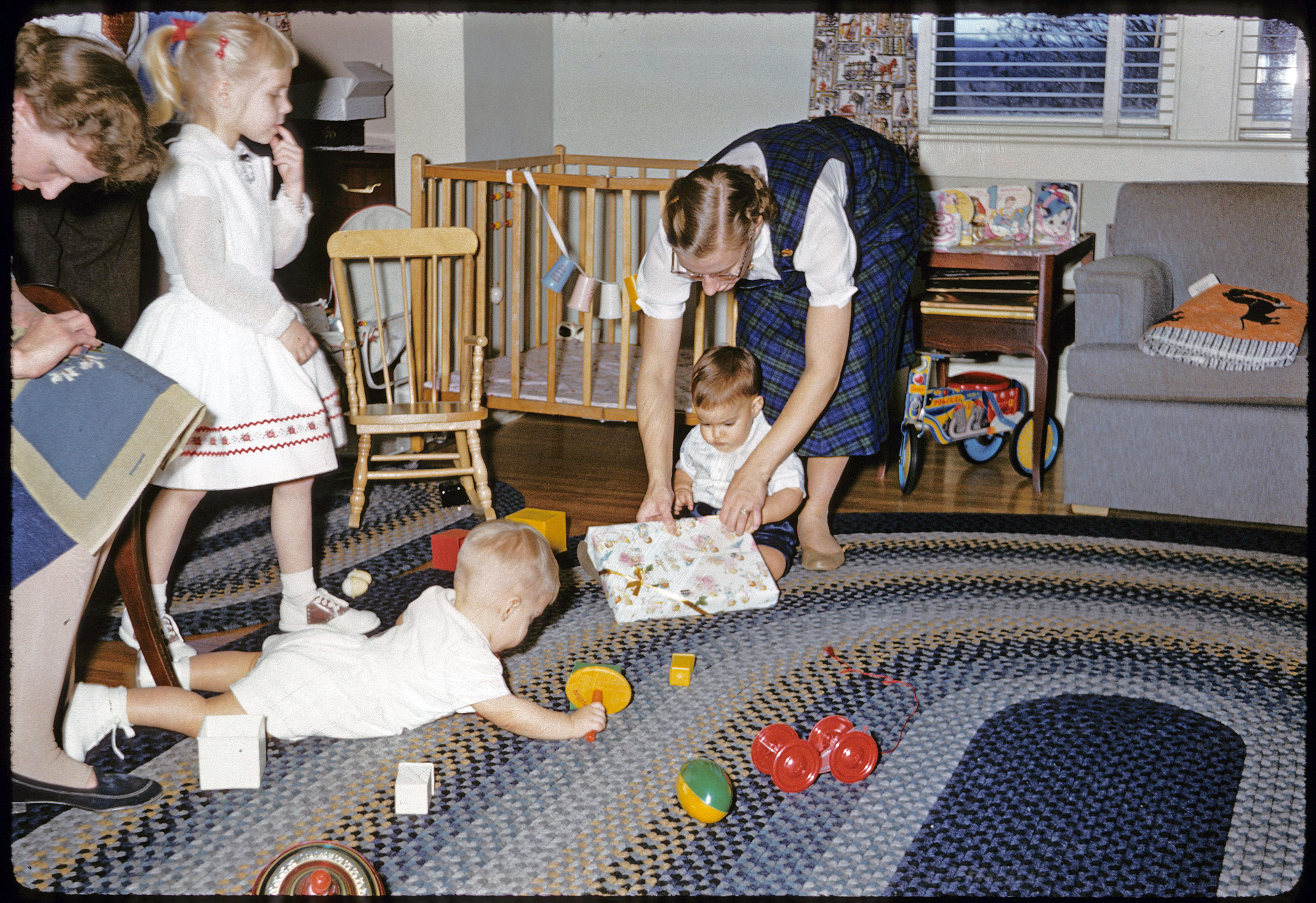 My brother's first birthday, 1957, East Aurora, NY. Cousins in attendance, myself in utero. Not the sharpest picture, but it fits well with another recent 1957 birthday picture posted here. The braided rugs, the toys, the clothes, my aunt's needlepoint project--all of possible interest. Taken, I believe, with my father's Minolta A Rangefinder. View full size.