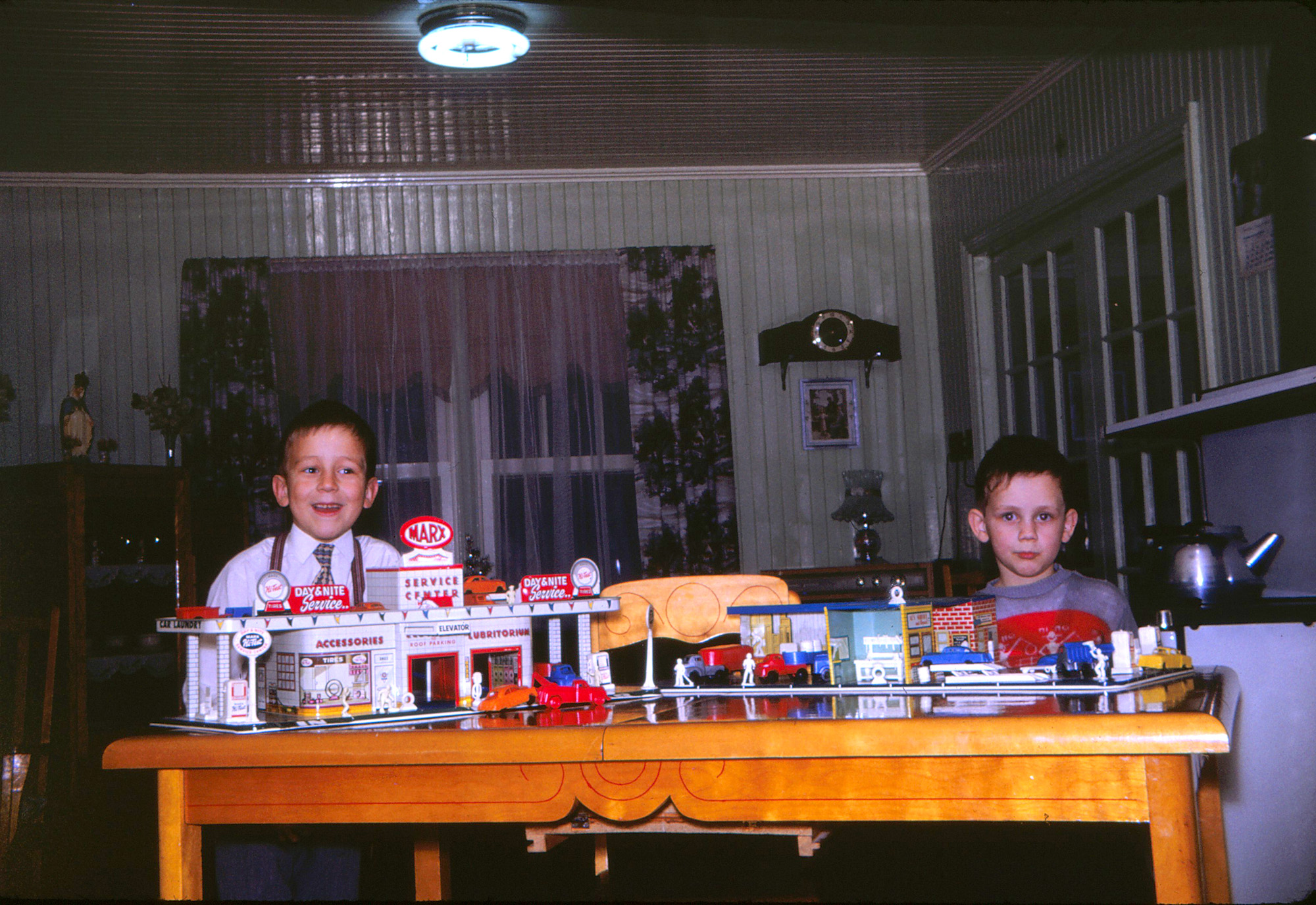 My brother, at left, and me, at right, proudly presenting our Christmas presents, nice garages with plenty of cars and trucks. View full size.