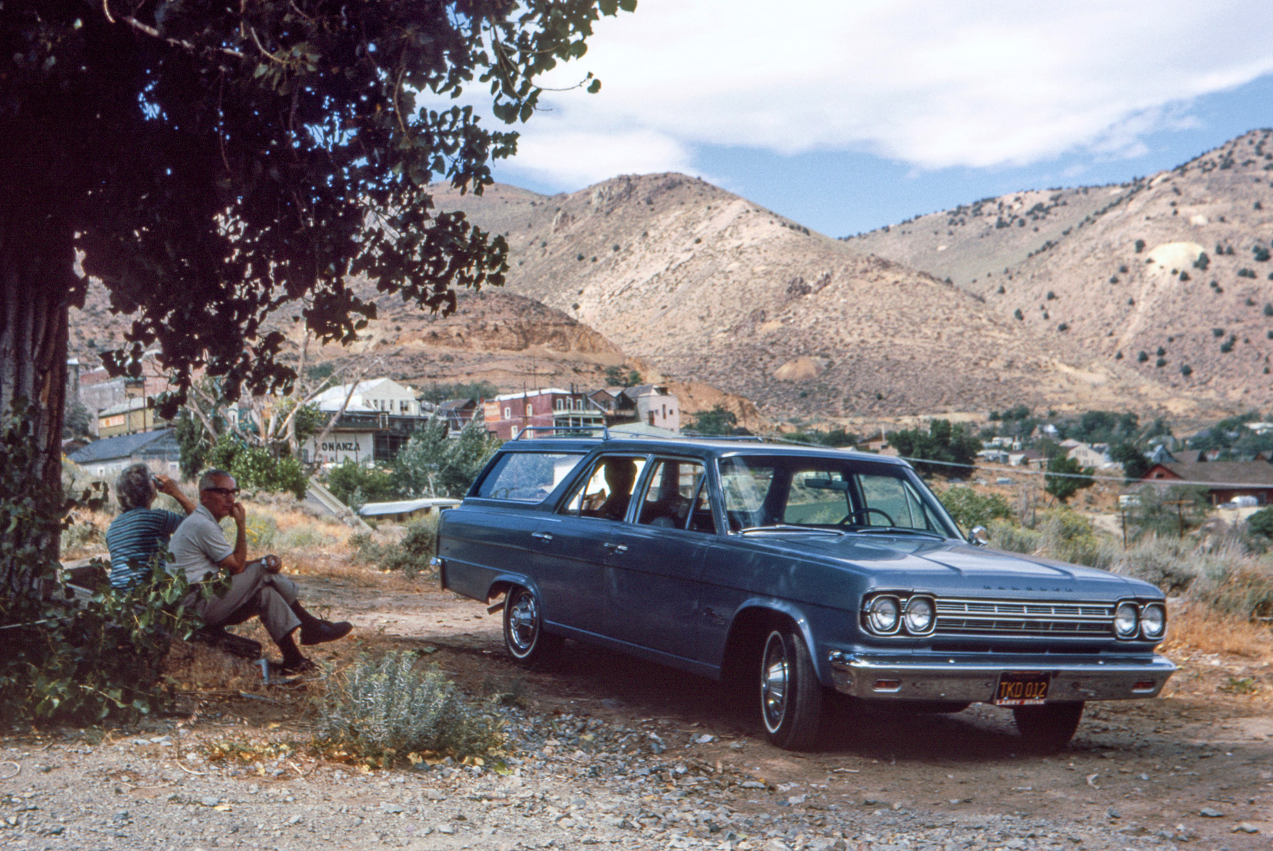 August 1966. Our brand-new Rambler Cross Country wagon on its first road trip, parked at the corner of Taylor and H Streets in Virginia City, Nevada. My mother swills Kool-Aid, my father picks his teeth, my brother occupies the back seat, and I click off this Kodachrome slide. View full size.