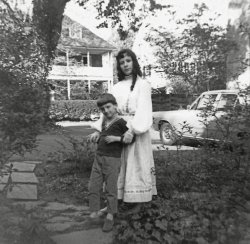 My mother took this picture of eighth-grade me and my first-grade brother at our front driveway in Haverford, Pennsylvania. To her it was a picture of her son and daughter. To me it is a picture of our 1967 Dodge Dart. Like when he bought the Studebaker, my father went through the options book with the dealer and had them make exactly what he wanted. Then we waited six weeks for the bespoke car to be built. So it was every bit as much of a dog as his first try at this special order stuff. 
Rubber mats again instead of carpets, 6-cylinder engine, no decorative trim. No wheel covers or whitewall tires. He did allow it to have a radio (AM only, no tape player) automatic transmission and air conditioner.  (To be fair my father was practical, not stingy. Pretty served no purpose. AC and heat did). Color was gold. When it came time to get rid of it, fifteen or so years later, he called me up and asked me if I wanted it. Though I usually took the family cast-off cars, in this case I said “no!”
Dearest AenthalPlease tell us how to pronounce your lovely name.
(ShorpyBlog, Member Gallery)