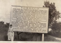 Taken in Zion, Illinois, circa 1915. 
Ha!This sounds like something my would write TODAY in 2007, nearly a hundred years after this photo was taken.
TobaccoI'm sending my friend who's a smoker this link.  She always says that they used to think smoking was good for ya! 
[Cigarette advertising of the early 20th century did indeed tout the supposedly medicinal, healthful qualities of tobacco. - Dave]
Really???You mean tobacco products aren't good for you?
WOW!This just blows me away!
I never would have thought they even had a clue about the bad effects of smoking back then..wow!
.
YepPublicly scolding other people for things you don't do is hardly a new vice.
&gt;&gt;&gt;I never would have>>>I never would have thought they even had a clue about the bad effects of smoking back then..wow!
Yes, they had to just guess, with nothing more to go on than the wracking cough, shortness of breath and bloody sputum!
Zion Illinois?I looked for more information on W.G.Voliva because I had never heard of Great Lakes, Illinois. There is the Great Lakes Naval Station that opened in 1911 but this photo is probably taken in Zion, Illinois.
http://en.wikipedia.org/wiki/Zion,_Illinois
Check out her handI've seen this before.
It's hard to tell in this copy but I believe she has a cigarette in her hand. Poking fun at the sign. 
this sign would be in Zion, IL and this is the guy who posted ithttp://en.wikipedia.org/wiki/Wilbur_Glenn_Voliva
All-consuming...I thought consumption was TB.
["While consumption usually signified tuberculosis in mid-nineteenth-century texts, the term covered a multitude of physical ailments characterized by weight loss resulting in death, including cancer." (Susan Sontag in "Illness as Metaphor.") - Dave]
Right again!Interesting to note from Wikipedia that W.G. Voliva also believed that the earth was a flat disk. I think his rant against tobacco products didn't spring from any deep medical or scientific insights but rather from a patholocigal tendency to regulate other people's lives.
Fake?The connection between lung cancer and smoking was discovered around 1930, so it could be that the sign is from the thirties (Wilbur died in 1942 according to Wikipedia). Still looks like photoshopped to me. At least, I'm surprised.
[A link between smoking and cancer (or consumption, as it was called) was posited at least as far back as the 19th century. Scientific or medical evidence didn't have much to do with it. The various temperance movements active at the time claimed all kinds of deleterious effects from tobacco use. - Dave]
(ShorpyBlog, Member Gallery)