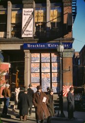 December 1940. Brockton, Massachusetts. "Men and a woman reading headlines posted in window of Brockton Enterprise newspaper office on Christmas Eve." 35mm Kodachrome transparency by Jack Delano. View full size.
