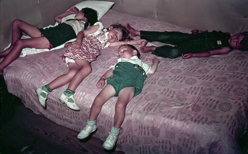 Children asleep on a bed during a square dance in McIntosh County, Oklahoma. Photograph by Russell Lee for the Farm Security Administration Office of War Information, c. 1939. View full size.