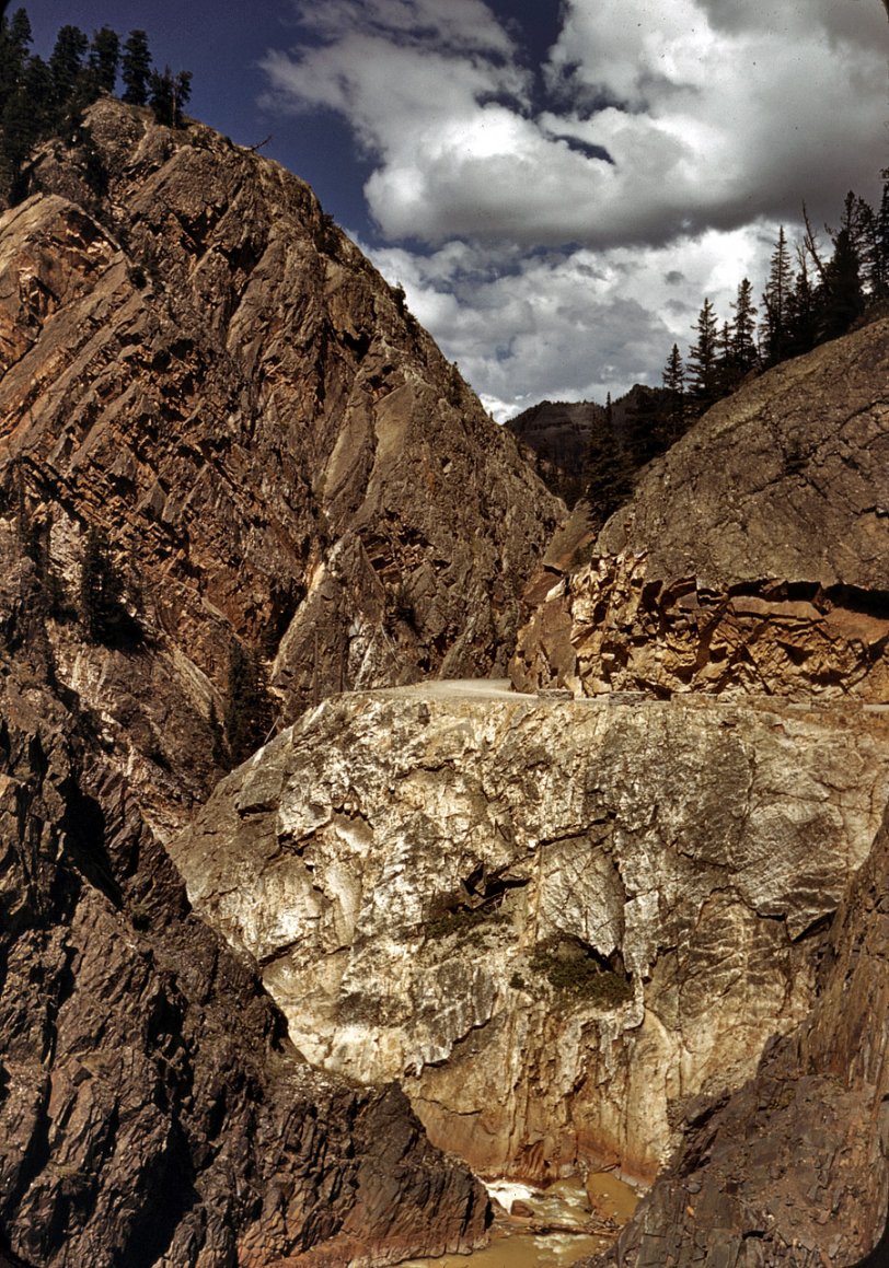 October 1940. "Million Dollar Highway is cut through massive rocks in Ouray County, Colorado." U.S. 550 between Silverton and Ouray. Now a paved modern highway, this is a spectacular mountain route that I've driven many times over the years. View full size. 35mm Kodachrome transparency by Russell Lee.
