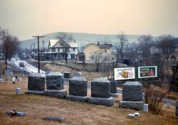 1942. "Cemetery at edge of Romney, West Virginia." View full size. 35mm Kodachrome transparency by John Vachon for the Office of War Information.
The Gaunt Brooding StateIn the book "John Vachon's America" (University of California Press), there are numerous letters written by him to his wife while he was on the road for the Farm Security Administration. In an entry dated January 24, 1942, he writes:
Romney, West Va. First day out. Night now, and many Saturday night people on the main street of this little town of dark West Virginia. The gaunt brooding state of the U.S. The West Virginia people have lean angular faces with dark seamed wrinkles. The bony women have thin breasts and strange sweet straight lips. Black Sunday suits on the men with combed hair, and shapeless color printed dresses on the women.
Country RoadsWest Virginia, mountain mama
Take me home, country roads.
At first glance, I thought this was another of tterrace's slides. Surprise, it's by John Vachon.  For photo historians, it must be nice to have the year prominently displayed on a billboard!
Fort Pitt AleGorgeous! What a lovely photo. Can anyone read the brand of ale in the billboard on the right? "Fort Pitt?"
["A toast to the holidays. Fort Pitt Ale." - Dave]

Dead Man&#039;s CurveThe road is Interstate 50, and the cemetery is Indian Mound.
Could have been yesterday.Aside from the car and the billboard, it almost seems as if this photo could have been taken yesterday. There are many areas which still look exactly like this. 
Indian MoundThat'd be US 50, not Interstate 50.
Fort Pitt Ale"A toast to the holidays"  Fort Pitt Ale.  Fort Pitt Brewing Company, Sharpsburg and Pittsburgh, PA(1906 - 1957).  Perhaps the best selling beer in the Pittsburgh area at one time and Romney was certainly within the marketing area of the brewery.  It vaguely looks like the woman on the billboard is wearing a ski outfit, but at that time skiing was far from the popular sport it is today.  Curiously, this sign may have explained the origin of a colloquialism known to many from Pennsylvania, "That's it, Fort Pitt" or the reverse, "Fort Pitt, That's It" was an advertising slogan for Fort Pitt Brewery.  See: http://www.flickr.com/photos/13ball/2334579584/
Also, I would note that there is no Interstate 50, but certainly a US 50.
Local breweriesLike Fort Pitt, there were a lot of breweries in the area of Allegheny County. Most of the buildings are still standing. Some still have that ascetic appeal of the early architecture of years ago. 
(The Gallery, Cars, Trucks, Buses, John Vachon)