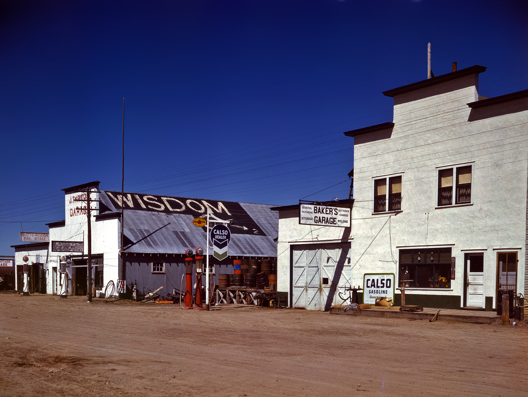 April 1942. "Baker's Garage in Wisdom, Montana. Largest town, population 385, in the Big Hole Basin, a trading center in ranching country." 4x5 Kodachrome transparency by John Vachon for the Office of War Information. View full size.