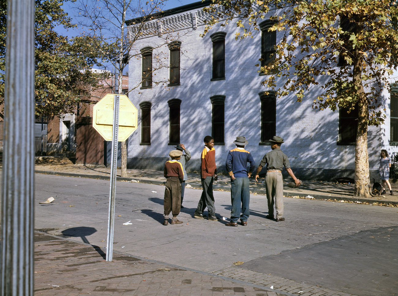 Boys with football at N and Union Streets S.W., Washington D.C. Autumn 1942. The scene at Shulman's Market, back when T-shirts were regarded as underwear and people wore actual clothes. View full size. Photograph by Louise Rosskam.