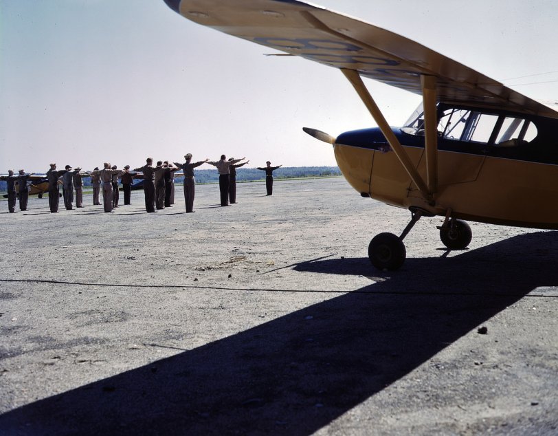 June 1943. Maneuvering in close formation at the Civil Air Patrol base at Bar Harbor, Maine. View full size. 4x5 Kodachrome transparency by John Collier.

