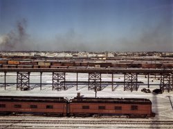 Chicago & North Western classification yard, December 1942. The trestle runs from the ice house to the yard. The old cars in the foreground are used as living quarters for some yard workers and itinerant help. Town of Melrose Park is in background. View full size. 4x5 Kodachrome transparency by Jack Delano.