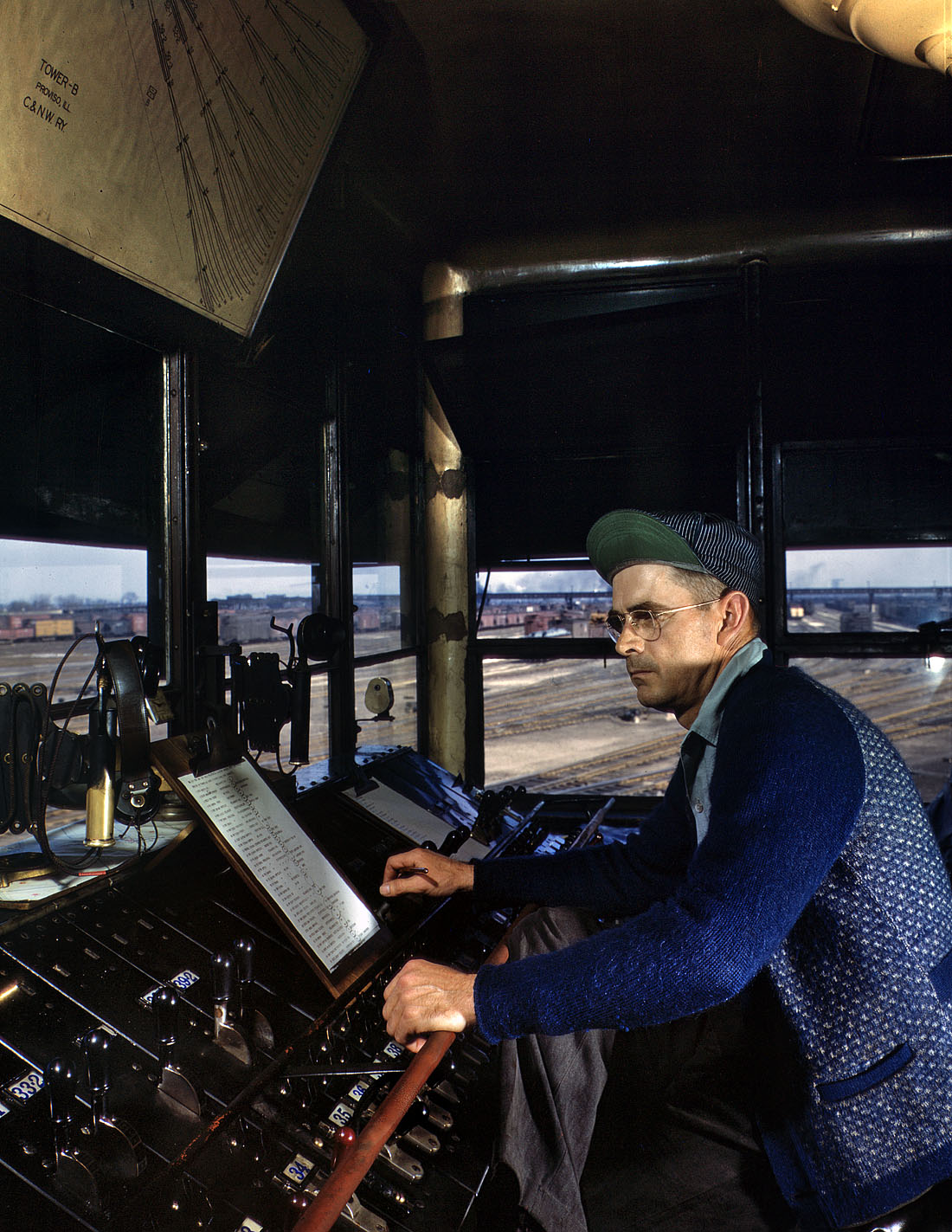 May 1943. Melrose Park, Ill. Chicago & North Western towerman R.W. Mayberry of Elmhurst at the Proviso Yard. He operates a set of retarders and switches at the hump. View full size. 4x5 Kodachrome transparency by Jack Delano.