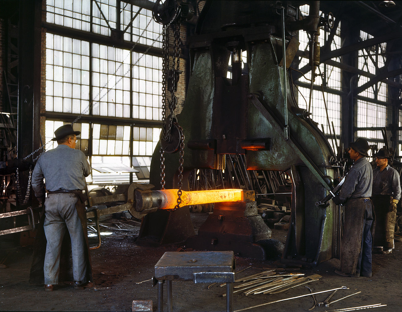 March 1943. "Santa Fe R.R. shops, Albuquerque. Hammering out a drawbar on the steam drop hammer in the blacksmith shop." 4x5 Kodachrome transparency by Jack Delano for the Office of War Information. View full size.