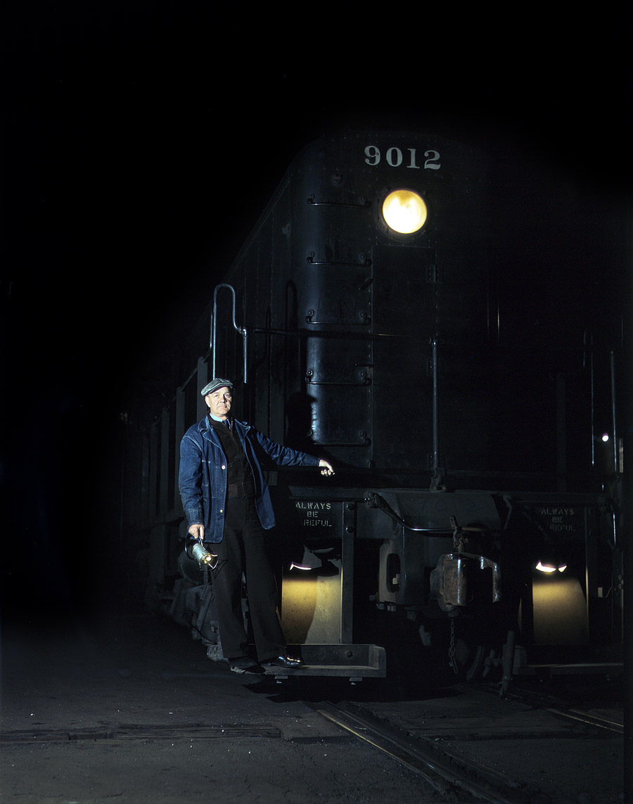 Vernon Brower riding the footboard of an Illinois Central diesel switch engine at the South Water Street freight terminal, Chicago. May 1943. View full size. 4x5 Kodachrome transparency by Jack Delano.