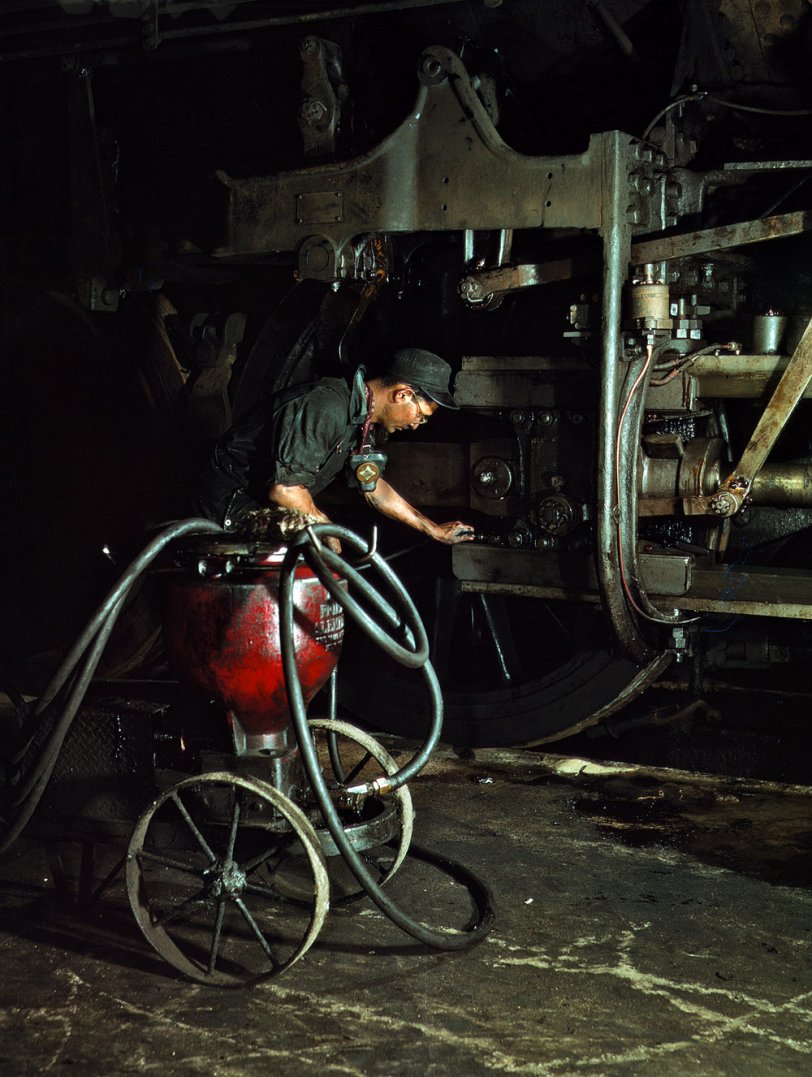 Thomas Madrigal greasing a locomotive in the roundhouse, Rock Island R.R., Blue Island, Ill. April 1943. View full size. 4x5 Kodachrome transparency by Jack Delano for the Office of War Information.
