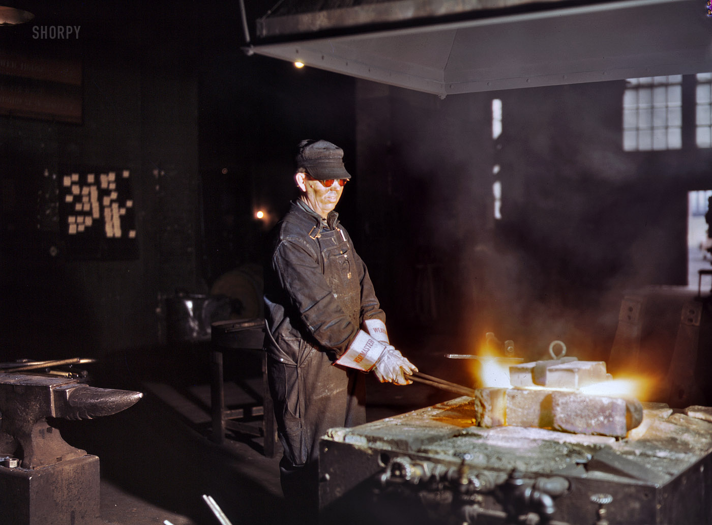 April 1943. Blue Island, Illinois. "John Kelseh, blacksmith, at his forge in the blacksmith shop at the roundhouse, Rock Island R.R." 4x5 Kodachrome transparency by Jack Delano for the Office of War Information. View full size.