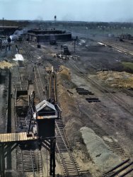 May 1943. Bensenville, Illinois. "Bensenville yard of the Chicago, Milwaukee, St. Paul, and Pacific Railroad. Track repair and work on the cinder pits at the roundhouse." 4x5 Kodachrome transparency by Jack Delano. View full size.