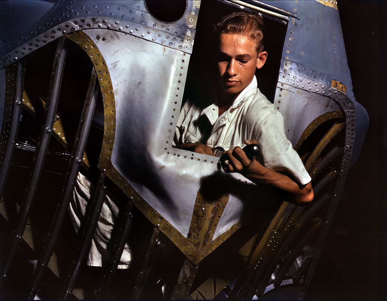 August 1942. Corpus Christi, Texas. "Working inside the nose of a PBY, Elmer J. Pace is learning the construction of Navy planes. As a National Youth Administration trainee at the Naval Air Base, he gets practical experience. After about eight weeks, he will go into civil service as a sheet metal worker." 4x5 Kodachrome transparency by Howard R. Hollem. View full size.