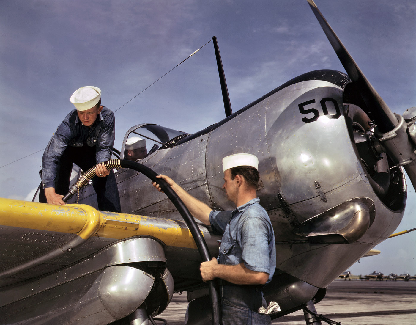 August 1942. "Feeding an SNC advanced training plane its essential supply of gasoline is done by sailor mechanics at the Naval Air Base, Corpus Christi, Texas." View full size. 4x5 Kodachrome transparency by Howard R. Hollem.