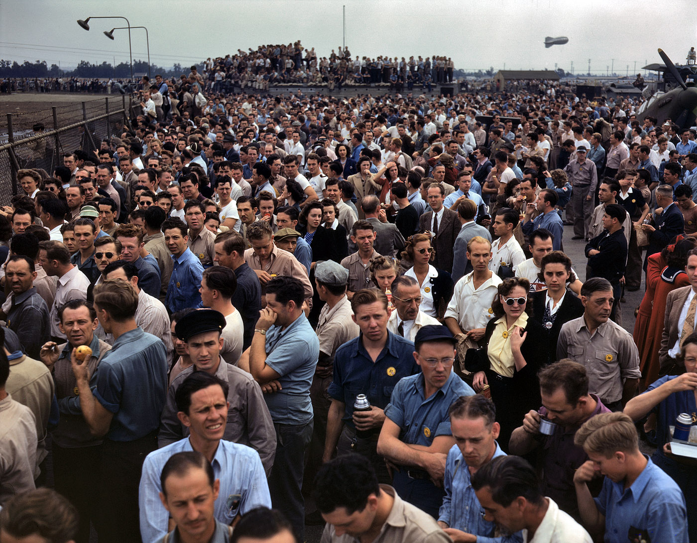 October 1942. "Thousands of North American Aviation employees at Inglewood, California, look skyward as the bomber and fighter planes they helped build perform overhead during a lunch period air show. This plant produces the battle-tested B-25 'Billy Mitchell' bomber, used in General Doolittle's raid on Tokyo, and the P-51 'Mustang' fighter plane, which was first brought into prominence by the British raid on Dieppe." View full size. 4x5 Kodachrome transparency by Alfred Palmer for the Office of War Information.