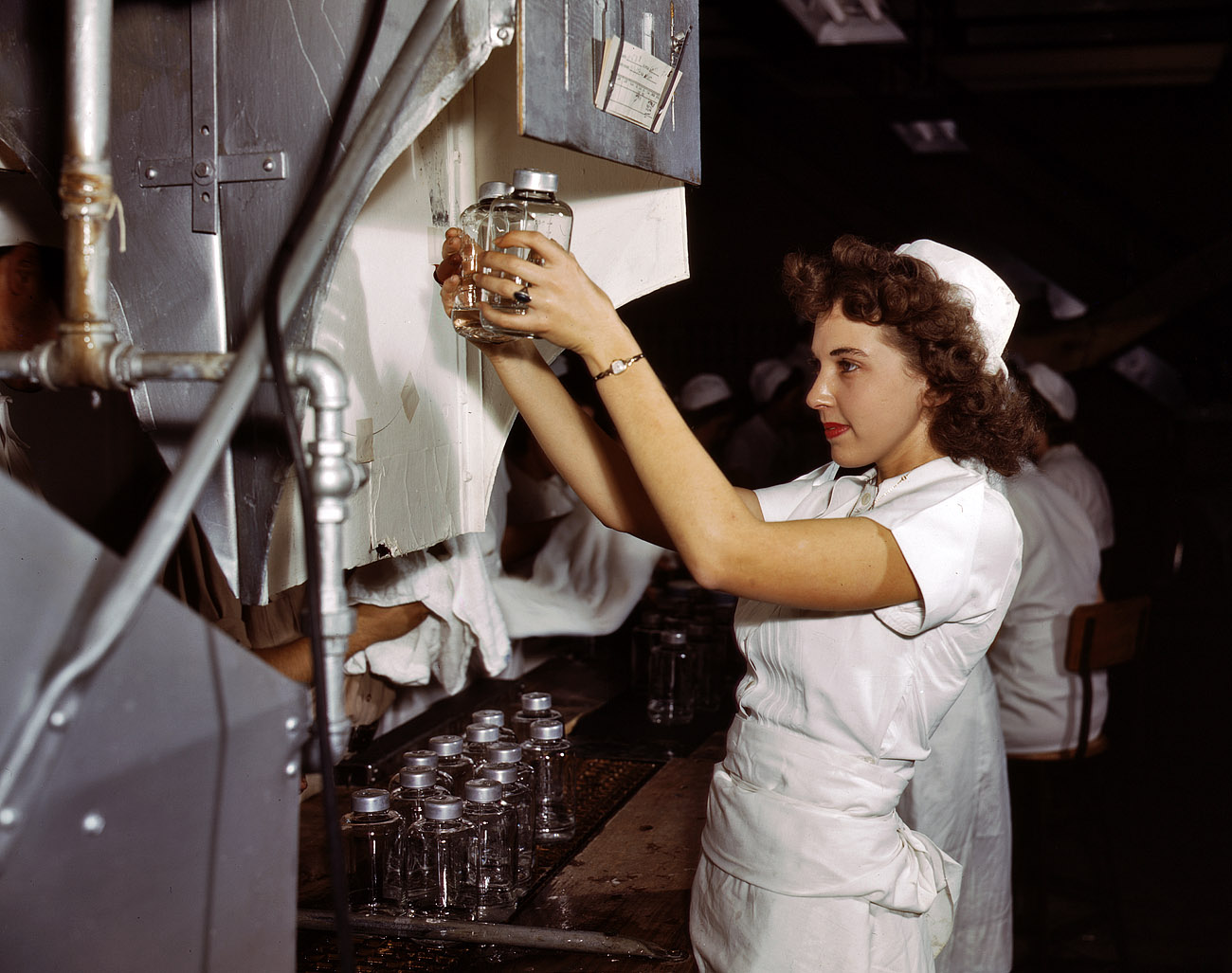 October 1942. Glenview, Illinois. "Transfusion bottles containing intravenous solution are given final inspection by Grace Kruger, one of many women employees at Baxter Laboratories. When her brother left Baxter to join the Merchant Marine, Miss Kruger, a former life insurance clerk, took his place." 4x5 Kodachrome transparency by Howard R. Hollem for the OWI. View full size.