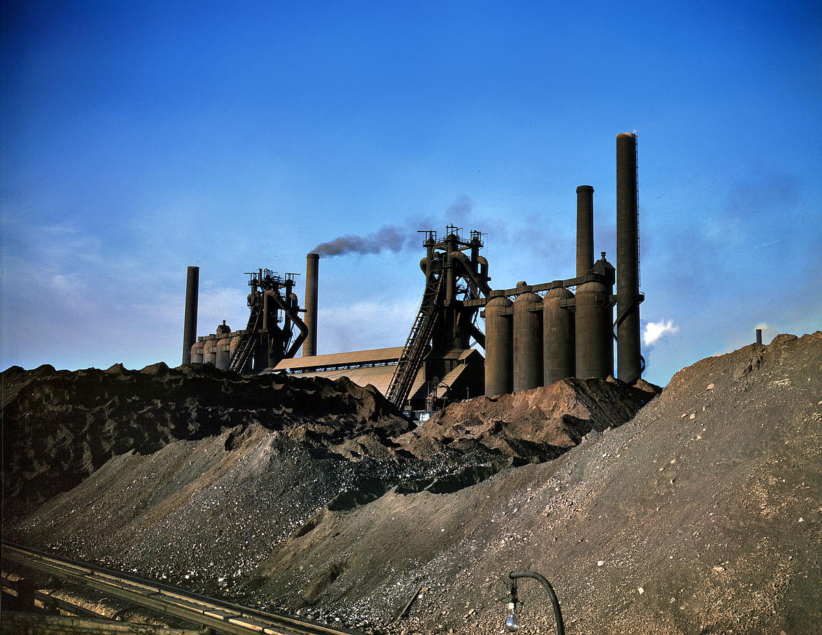 November 1941. Iron ore piles and blast furnaces of the Carnegie-Illinois steel mill in Etna, Pennsylvania. View full size. 4x5 Kodachrome transparency by Alfred Palmer for the Office of War Information.