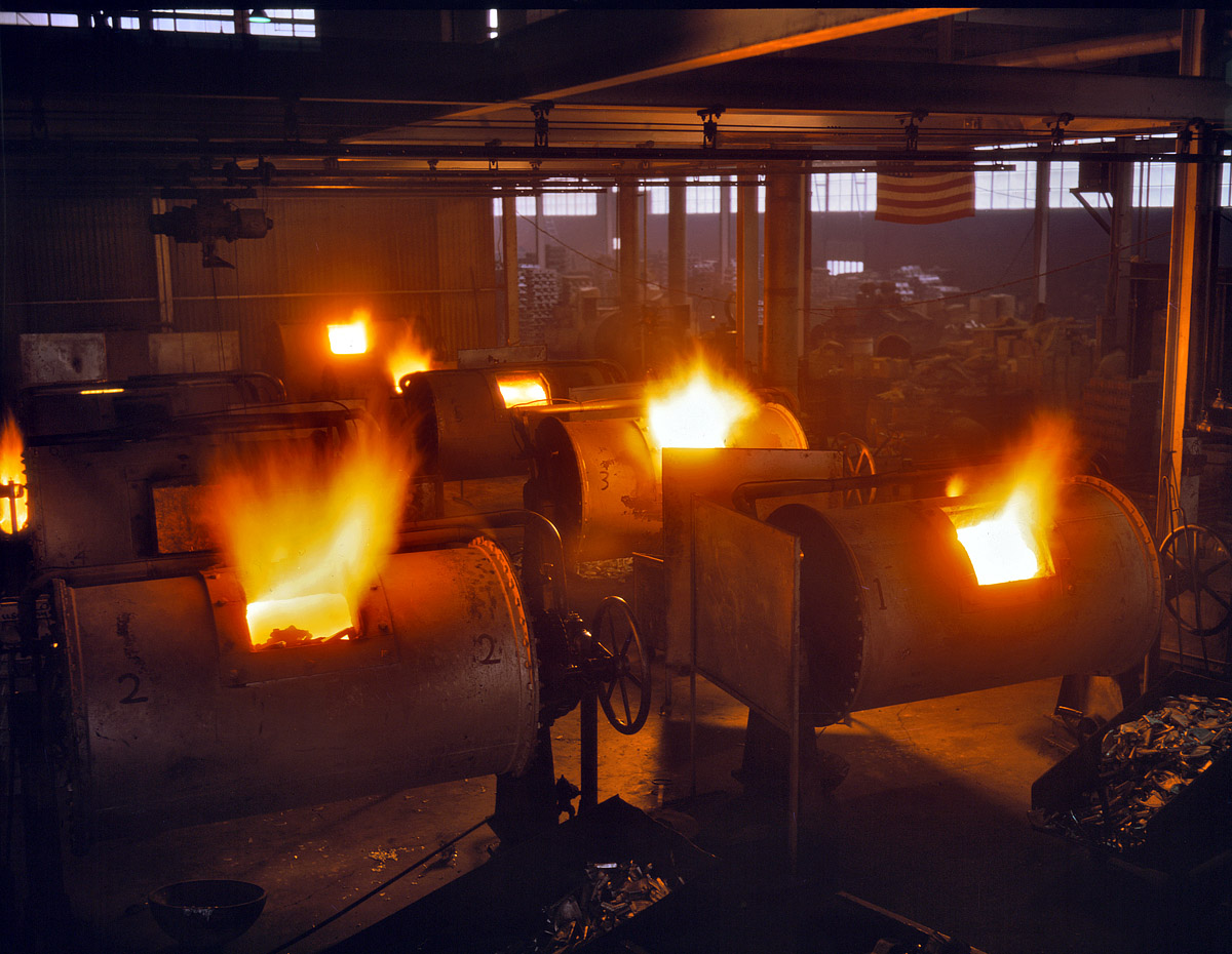 February 1942. Cincinnati, Ohio. "A battery of 1,000- and 2,000-pound furnaces roaring threats to the Axis. These are rotary oil-fired melting furnaces at Aluminum Industries Inc. Destination of the finished aluminum products is kept secret." 4x5 Kodachrome transparency by Alfred Palmer. View full size.