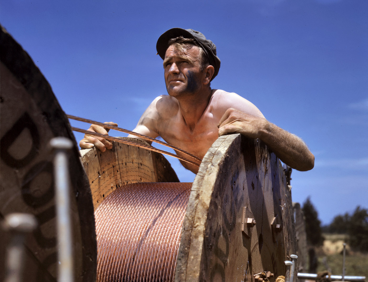 June 1942. "This husky member of a construction crew building a 33,000 volt power line into Fort Knox is performing an important war service. Thousands of soldiers are in training there, and the new line from a hydroelectric plant at Louisville is needed to supplement the existing power supply." 4x5 Kodachrome transparency by Alfred Palmer, Office of War Information. View full size.