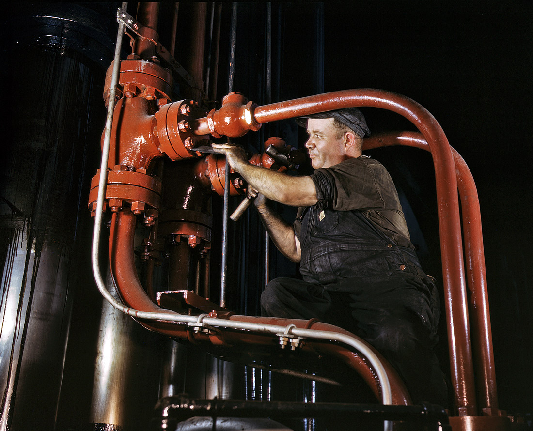 June 1942. Combustion Engineering maintenance man working on world's largest cold steel hydraulic press in Chattanooga. It can shape steel plates several inches in thickness. View full size. 4x5 Kodachrome transparency by Alfred Palmer.