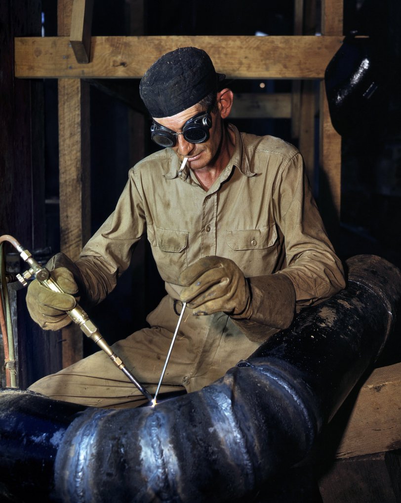 June 1942. Gas-welding a joint in a line of spiral pipe at the Tennessee Valley Authority's new Douglas Dam on the French Broad River. View full size. 4x5 Kodachrome transparency by Alfred Palmer, Office of War Information.

