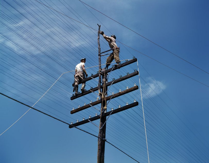 June 1942. Working on power transmission and utility lines near the TVA hydro- electric plant at Chickamauga Dam or Douglas Dam, Tennessee.  View full size. 4x5 Kodachrome transparency by Alfred Palmer, Office of War Information.