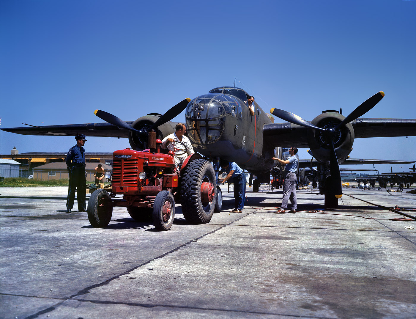 October 1942. Kansas City, Kansas. "B-25 bomber plane at North American Aviation being hauled along an outdoor assembly line." View full size. 4x5 Kodachrome transparency by Alfred Palmer for the Office of War Information.