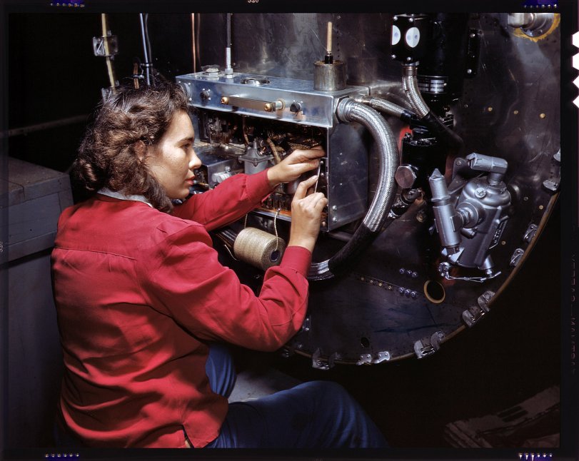 October 1942. Assembling switchboxes on the firewalls of B-25 bombers at North American Aviation's Inglewood, California, factory. View full size. 4x5 Kodachrome transparency by Alfred Palmer, Office of War Information.
