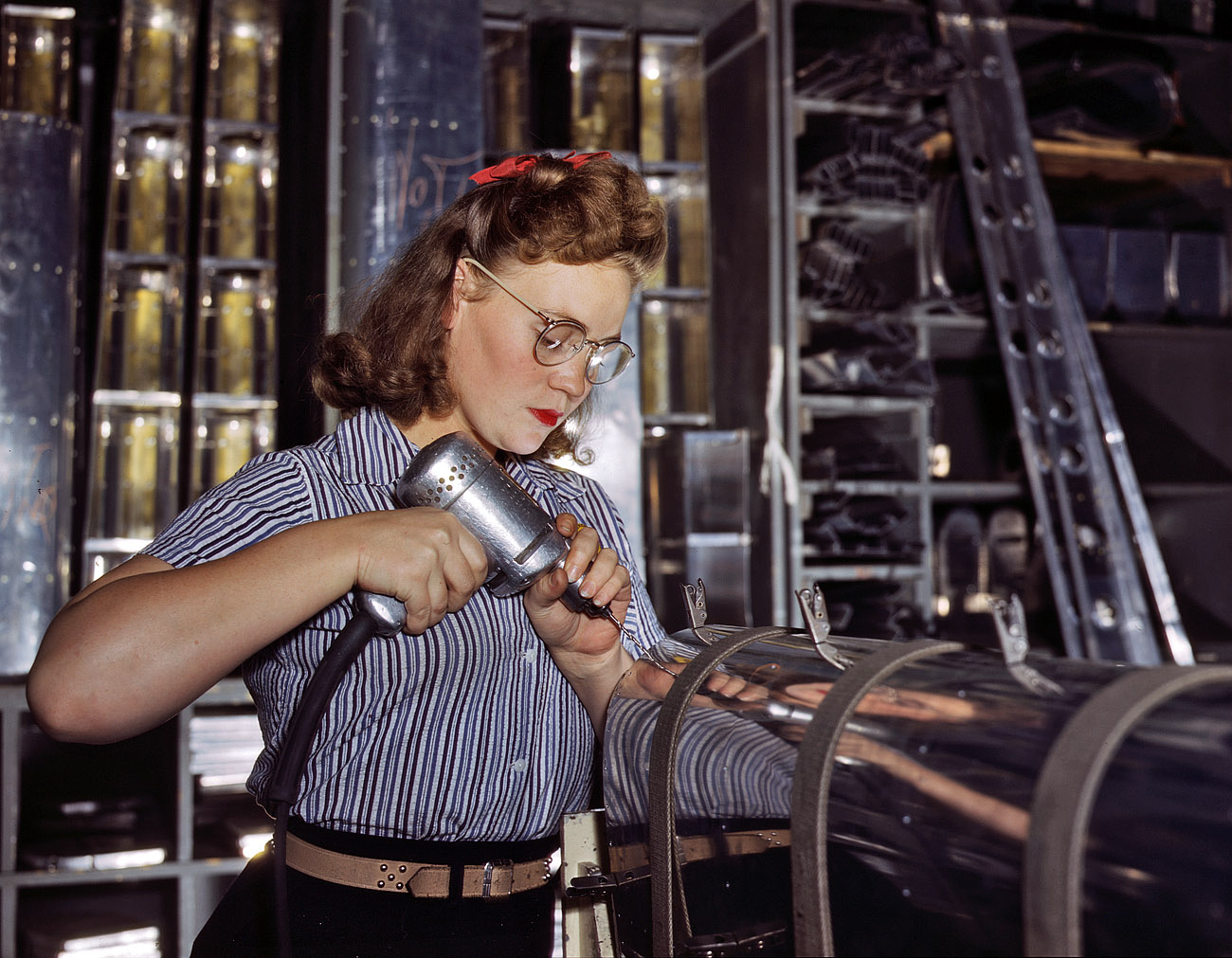 October 1942. Inglewood, California. North American Aviation drill operator in the control surface department assembling horizontal stabilizer section of an airplane. View full size. 4x5 Kodachrome transparency by Alfred Palmer.