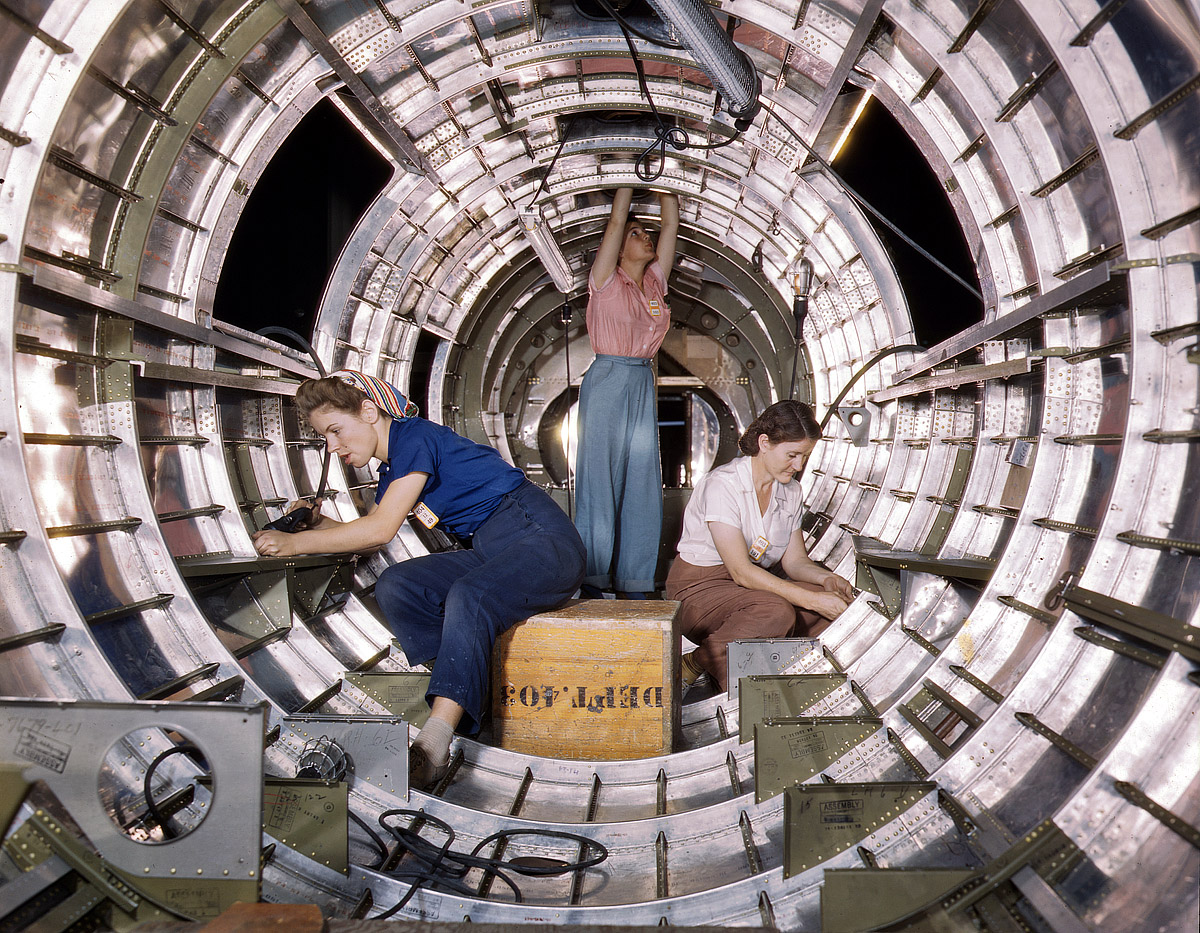 October 1942. Workers installing fixtures and assemblies in the tail section of a B-17F bomber at the Douglas Aircraft Company plant in Long Beach, California. View full size. 4x5 Kodachrome transparency by Alfred Palmer.