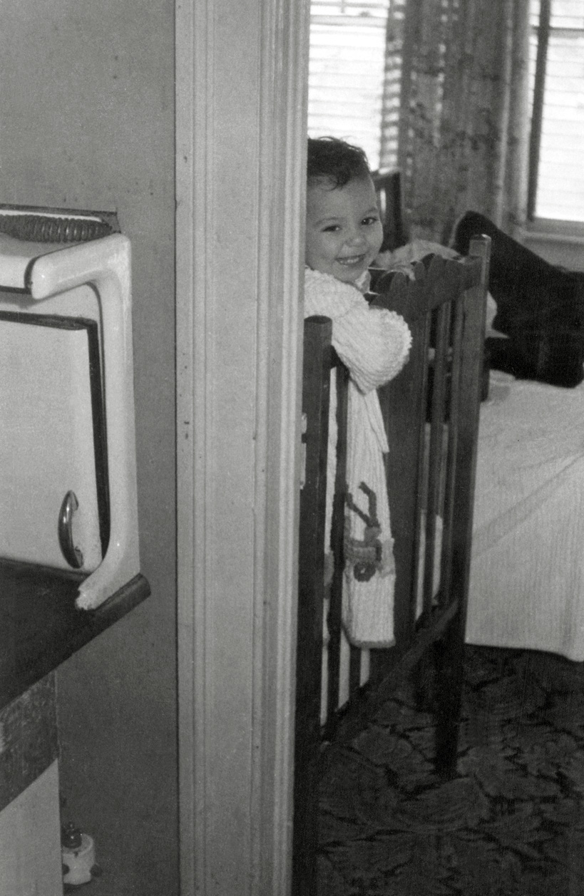My mother in her crib. She used to reach around the corner and play with the stove. View full size.
