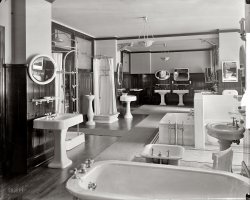 Washington, D.C., circa 1920. "Standard Sanitary Manufacturing Co." And the potty's over -- over behind that partition. Harris &amp; Ewing. View full size.
Daily columnistLooks like a hand-washing fountain, smaller than the one I remember from elementary school but the same basic idea. 
Sanitary BuildingYou can still see it from from the Red Line Metro between Union Station and Brookland. The name is visible along the roof line, although this business is gone.
Two-faucet sinkThis photo reminds me:  My grandparents lived in an apartment with a two-faucet sink in the bathroom.  As a child, I never could get the hang of washing my hands -- turned on both faucets, and quickly switched between hot-cold-hot-cold-hot-cold so as not to scald or freeze my hands.  (I suppose what was expected was to fill the bowl with mixed-temperature water first?)  This was in the 60s and I wonder how old that sink was.  I've never seen that anywhere else.
Better then than todayFrom American Standard's site: Before American Standard, there was the Standard Sanitary Manufacturing Company. It was founded in 1875, and merged with several other small plumbing manufacturers in 1899 to form the Standard Sanitary Manufacturing Company. By 1929, Standard had become the world's largest producer of bathroom fixtures.
As a person who is now shopping for a the right oval pedestal sink, I think I've found it, at the front left.  And that I'll take that multi-head shower to the far right and the deep tub.
 Art in PlumbingLong ago I remember visiting one of the mansions of the really wealthy along the Hudson. I have long since forgotten which it was but I still remember being amazed at the quality and design of the gleaming chrome plated brass piping and sculpted fittings that led to the bathroom fixtures. And the skill of the plumbers to assemble all perfectly without nary a scratch.
One can get more than a hint at what I mean in this picture. But, I would bet what I saw in that mansion was custom made or imported from a European specialty house.
MirrorsWhat a great showroom! I found myself looking at the reflections in the mirrors more than anything else. There are even reflections of reflections.
Also, I think if you're looking for the potty, you might find some just left of the frame.
Seizures startingAfter studying this collage of mirrors, reflections within reflections and dazzling chrome flashes, I am starting to go into seizures like that person who has them when he hears the voice of Mary Hart.  This photo is quite intriguing but for your own mental stability, do not look at it for too long.  Geez, I need a drink.
Love the showerTHe mult-headed shower in the foreground is fantastic!
Curious what the column next to it is, a water fountain? 
Eight heads are better than oneToday's multi-head showers have nothing on that one, at left. And, it looks like potties reflected in the rectangular mirror on the far wall-- they must be behind and left of the camera. Maybe it was indelicate to show a WC in photos of that era.
No terletsIt's funny that no toilets are openly pictured. I wonder if that's just the way this composition worked out best or if the photographer took deliberate aims to "avoid the vulgar."
Beautiful &amp; Classic DesignsI am especially intriqued by the shower that would look awesome in my bungalow bathroom that is being renovated.  Anyone know where somethig like that can be purchased?
This showroom was located in the Southern Building, 1421 H Street, NW.
Looking for the loo?Look in the rectangular mirror on the far wall.  The toilets are visible beyond the square sink on the left. 
The potty can be seenIt has a wooden lid, and is reflected in the rectangular mirror furthest right.
What is that vase-shaped porcelain object, with the chrome fixture on top of it, placed between the two shower stalls (one a "needle-point")? Some kind of home drinking fountain? It's too tall for a bidet.
ClassicsI could live very comfortably with these antique fixtures.
Water saver?  Pfft!Ah, the good old days, when a showerhead was really something to behold.
Brings Back MemoriesMy grandmother had fixtures just like this.  Her bathroom was classic.  The toilet was situated behind a half wall. The floor was black and white tiling, and the walls were tiled half way up.
I would love to get my hands on one of those shower bases!
Showroom LocationIt appears that this showroom was in the Southern Building which still stands at the corner of 15th and H.



All over your bodyI count 9 shower heads on one of those curtained contraptions.  Your house better have very strong water pressure to accommodate all those outlets.
Retro FitHow lovely - I'd take almost any of these setups today. I thought at first that it was odd there were no toilets showcased, but if you look in the reflection of the squareish mirror on the far wall, it looks like the toilets must be lined up on the opposite side of the showroom, all together. 
So what's the thing on the left, beside the second setup back? Looks like a water fountain, but that doesn't seem right. 
Found the potties!The toilets are visible in the reflection of the square mirror at the back.  By this it would seem they're just out of frame to the photographer's left.  I would suspect that they weren't considered nice enough to share space with the other fixtures and I know that many homes from that era had the toilet in a separate room off the main bathroom.  
Upon further reflectionI count nine mirrors total, seven with visible reflections, and not a single glimpse of the photographer in any of them.  And all this without Photoshop to fix mistakes after the fact.
Although I do wonder whose thumbprint that is.
Gone ForeverOther than junkyards, I bet you couldn't find a sitz bath anywhere -- but you could get one here.  
Modern SanitationAmazingly, the Standard Sanitary Mfg. Co. published a monthly magazine entitled Modern Sanitation. Volumes 10 &amp; 11 (24 issues!) are online at Google Books.  It's chock full of interesting  photos, advertisements and articles ("Where Bathing Makes Real Manhood and Womanhood", "Sanitation among the Hopi Indians","Bathing Facilities of the Modern Steamship" and "Japan, a Nation of Cleanliness.")
&quot;The Plumber Protects the Health of the Nation&quot; was the the old poster from an early American Standard Promo http://plumberprotects.com/ Standard Sanitary Morphed into that
company.  As a Plumbing Wholesaler for 20+ years I'm fascinated
with this picture.  I sell many plumbing parts now and it's amazing
how many times a homeowner walks in and asks for parts for
faucets and toilets contemporary with these.  They don't make 'em
like that anymore but they ARE still out there! 
Found it!Thanks to stanton_square's post, I found the mystery pedestal in "Modern Sanitation"  It is a "Bubbling Valve Drinking Fountain" -- although the version in the picture doesn't seem to have the china mouthpiece.
 
FixturesWe own a circa 1902 house and have a sink that is a reproduction of the ones on the far wall. Now, if I only had room for a claw foot tub like the one we had in our 1892 house!
Two-Faucet Sinks, yes.> This was in the 60s and I wonder how old that sink was.
> I've never seen that anywhere else.
Two faucet sinks used to be fairly common, and they're still nearly universal in the UK and Ireland. 
It's not a matter of backwardness - there was a good reason not to use mixing faucets. In earlier days here in the US (and often today, over there) it was common to have cold water fed directly at line pressure from the street, while hot water came at a constant pressure from a cistern on an upper floor. Mixing faucets would allow the stored hot water to be siphoned back into the street if there was a drop in supply pressure, so they were not allowed for sanitary reasons.  
Shower pan and needle showerI put a bid on a house that had both of those fixtures intact; it was an upper-middle class home, built in 1919. When I was un real estate you would run into needle showers fixtures up through the early 1930s. They were considered very healthy, especially for men, because they woke up your circulation.
There's an article about the evolution of shower technology here:
http://www.theplumber.com/standup.html
You can still buy a shower pan like that today. Here's one, porcelain on chrome or porcelain feet, from Van Dyke's Restorers, only $1,499. 
More Cold Than HotLet's not lose sight of the fact that, despite all these  plumbing niceties, hot water was in short supply for most people at that time.  My experience over 20 years later involved a gas fired coil of copper tube that had to be lit whenever hot water was wanted.  We kids were sequentially bathed in the same water. (Once a week, I might add.)
(The Gallery, D.C., Harris + Ewing, Stores & Markets)