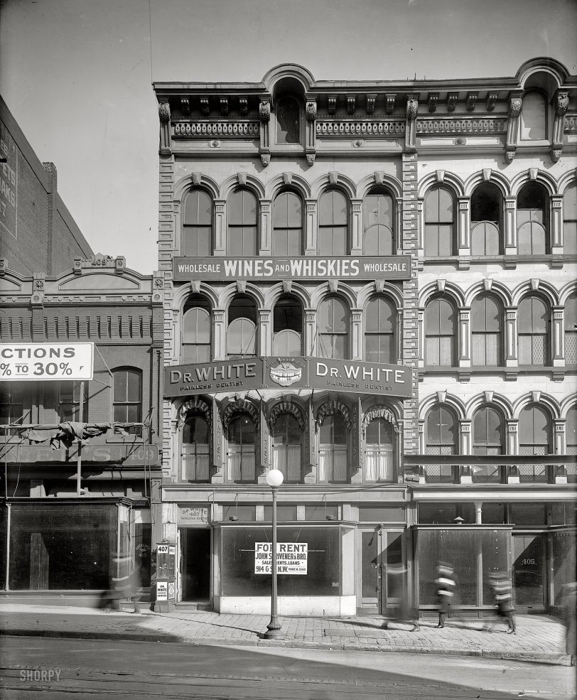 Washington, D.C., circa 1918. "Emergency Fleet Corporation, building exterior." Do streetscapes come any better than this?  An interesting juxtaposition of signs (Painless Dentist, Wines &amp; Whiskies), and of course there's that ghastly set of rotten choppers. Harris &amp; Ewing Collection glass negative. View full size.
