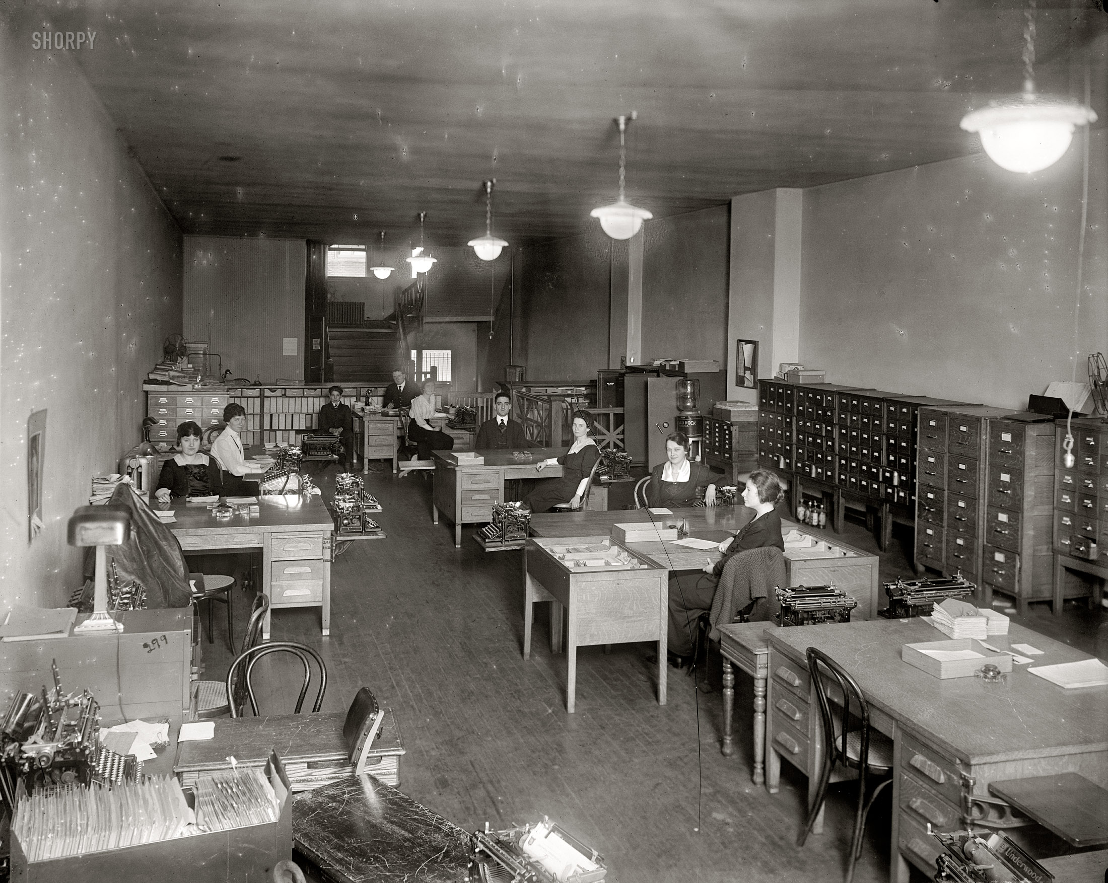 Washington, D.C., circa 1919. "Underwood Typewriter Co." An interior view of the Underwood office on New York Avenue whose exterior we saw in the previous post. Really, who needs distracting windows when we have this marvelous artificial lighting? Harris & Ewing Collection glass negative. View full size.
